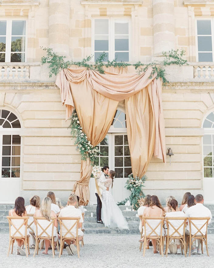 A wedding ceremony in front of a grand chateau in Normandy, France.