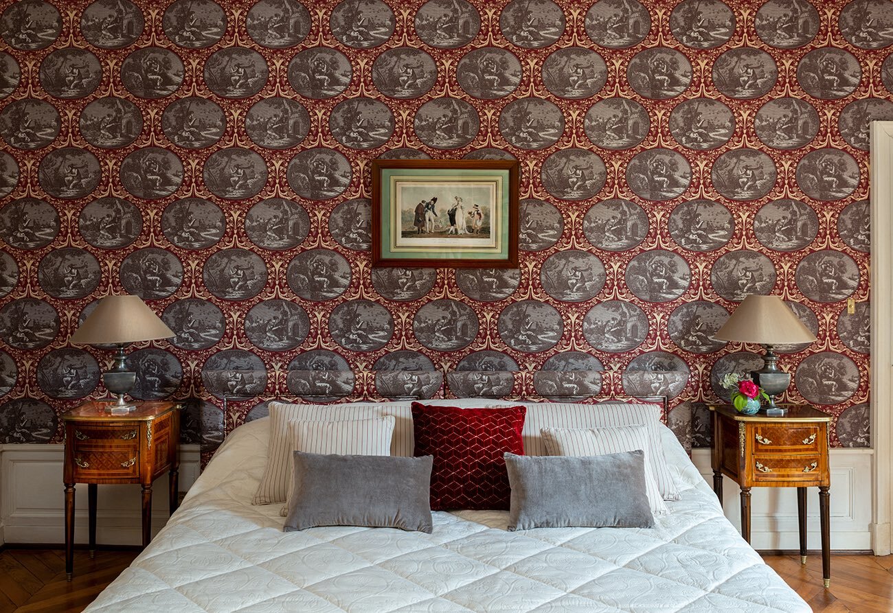 A bedroom with ornate wallpaper and a luxurious bed available to rent.
