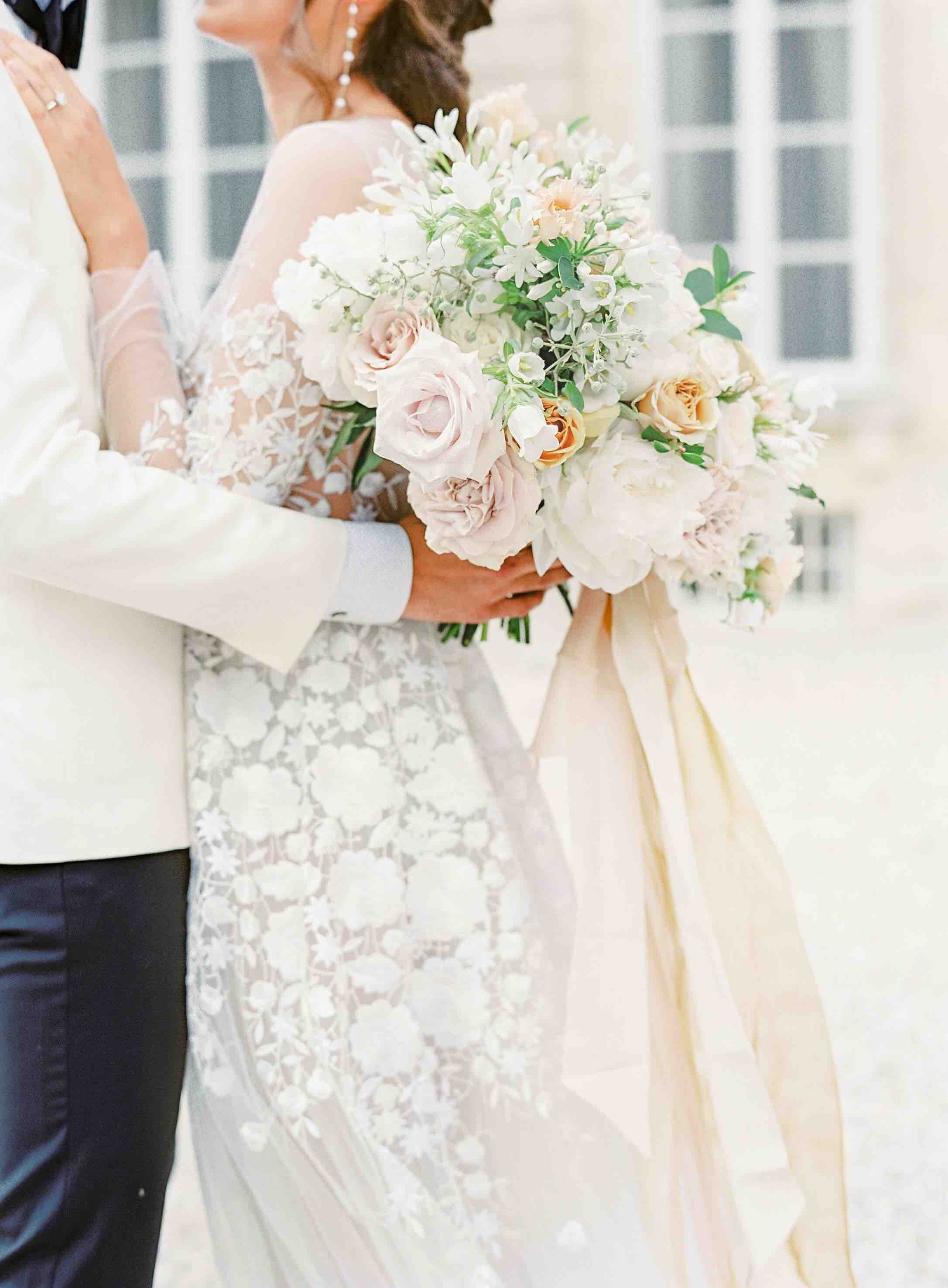 A bride and groom embracing in front of Chateau de Courtomer, a French chateau available for wedding hire.