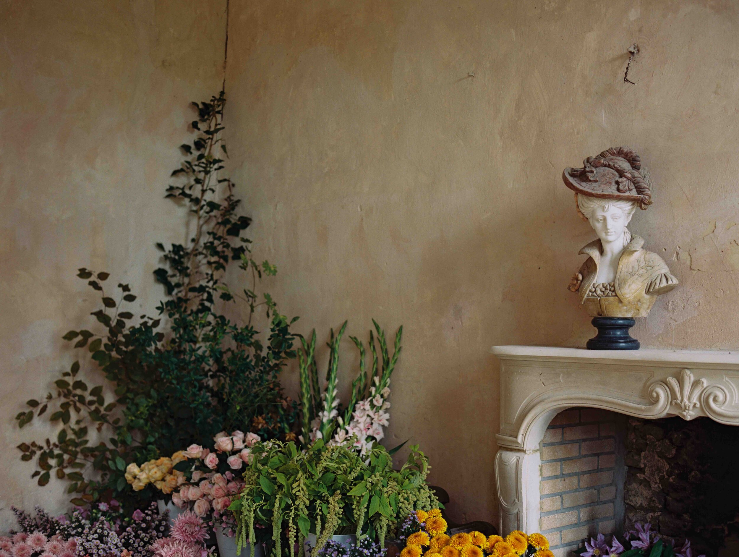 A room filled with flowers around a cozy fireplace, created during the Ponderosa and Thyme workshop, an event at the chateau.