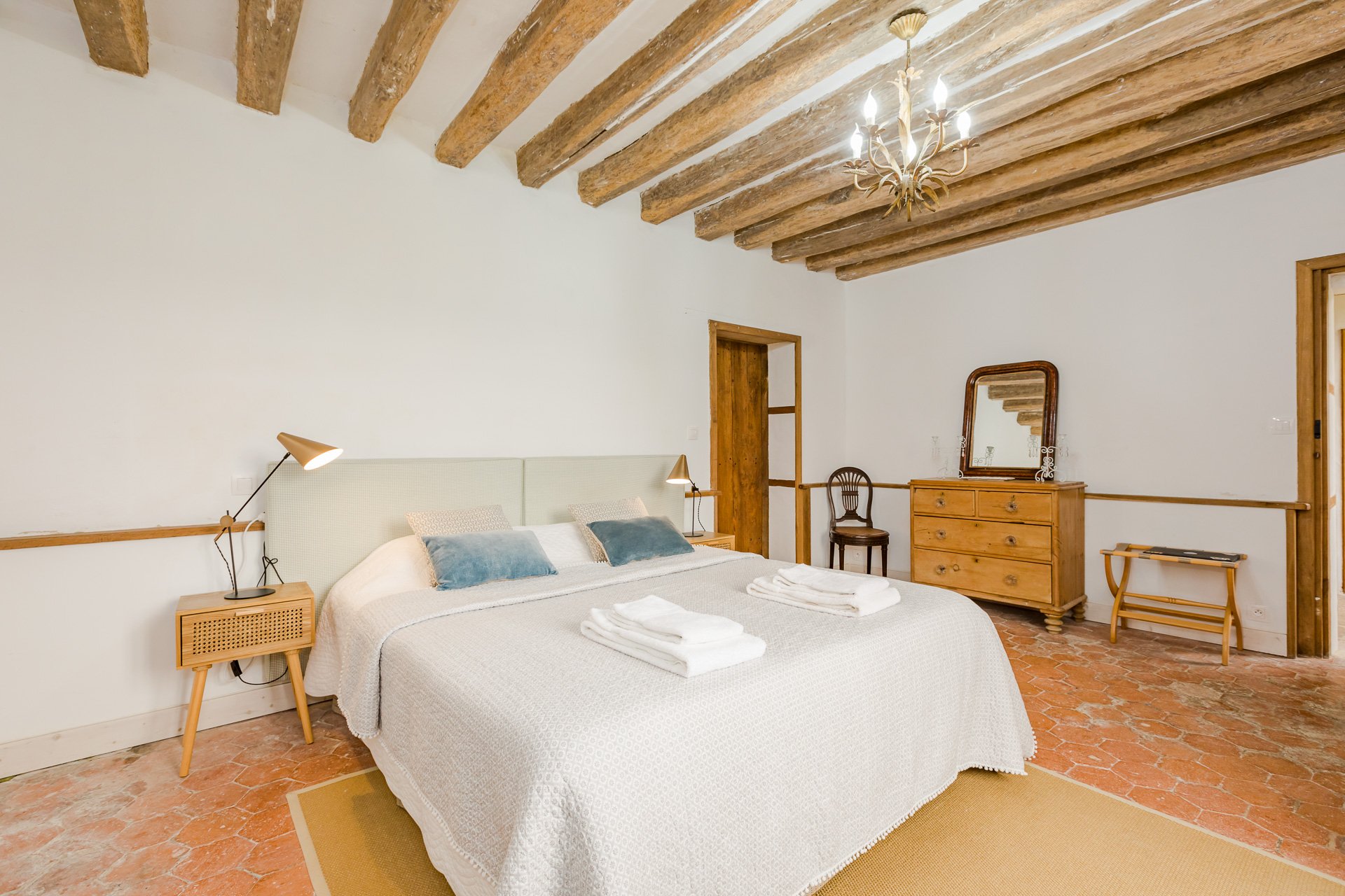 A cozy en suite bedroom with beamed ceiling in the farmhouse on the grounds of Chateau de Courtomer.