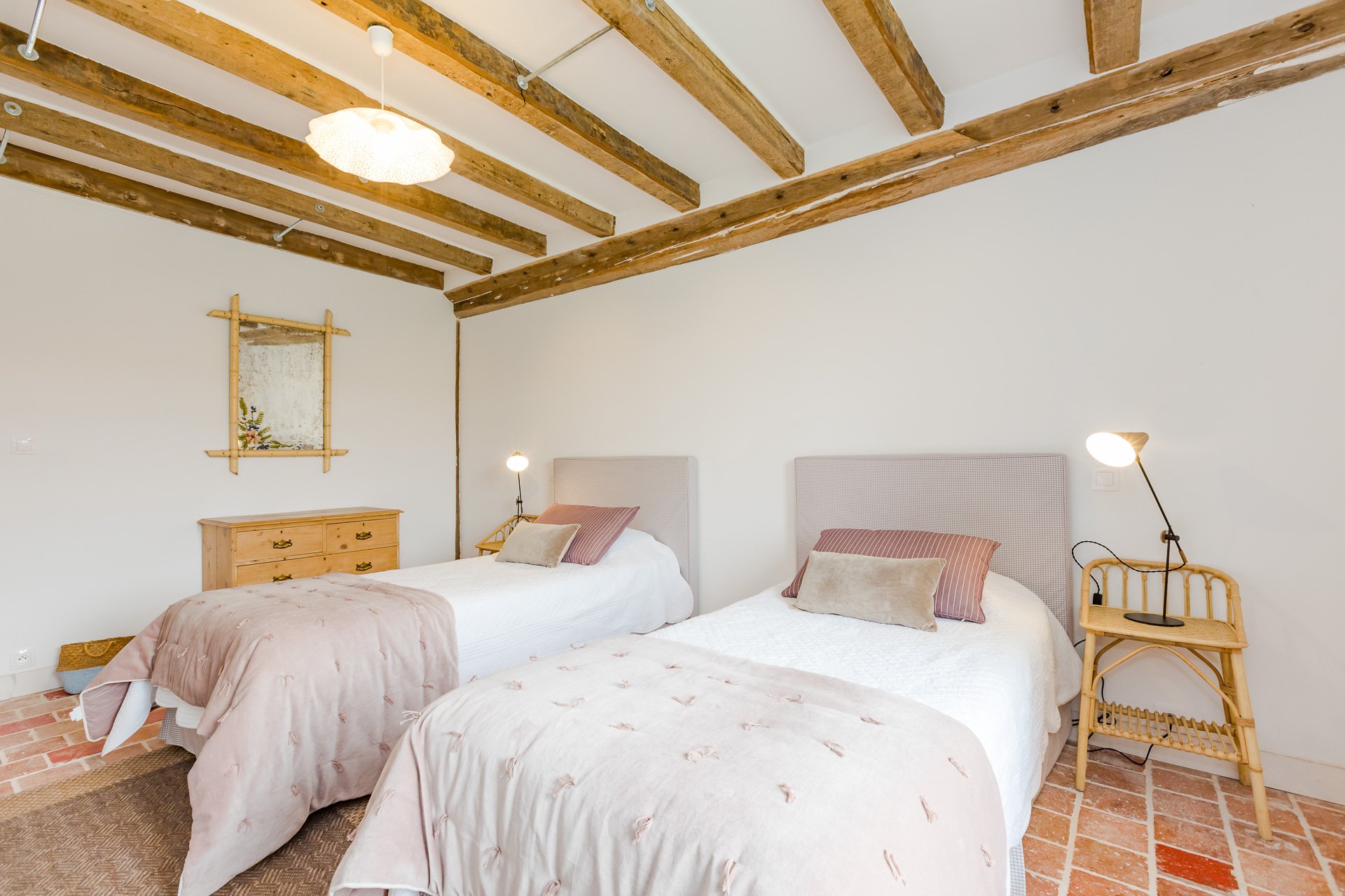 A light filled, twin bedded room overlooking the farmyard in a cosy holiday cottage in Normandy.