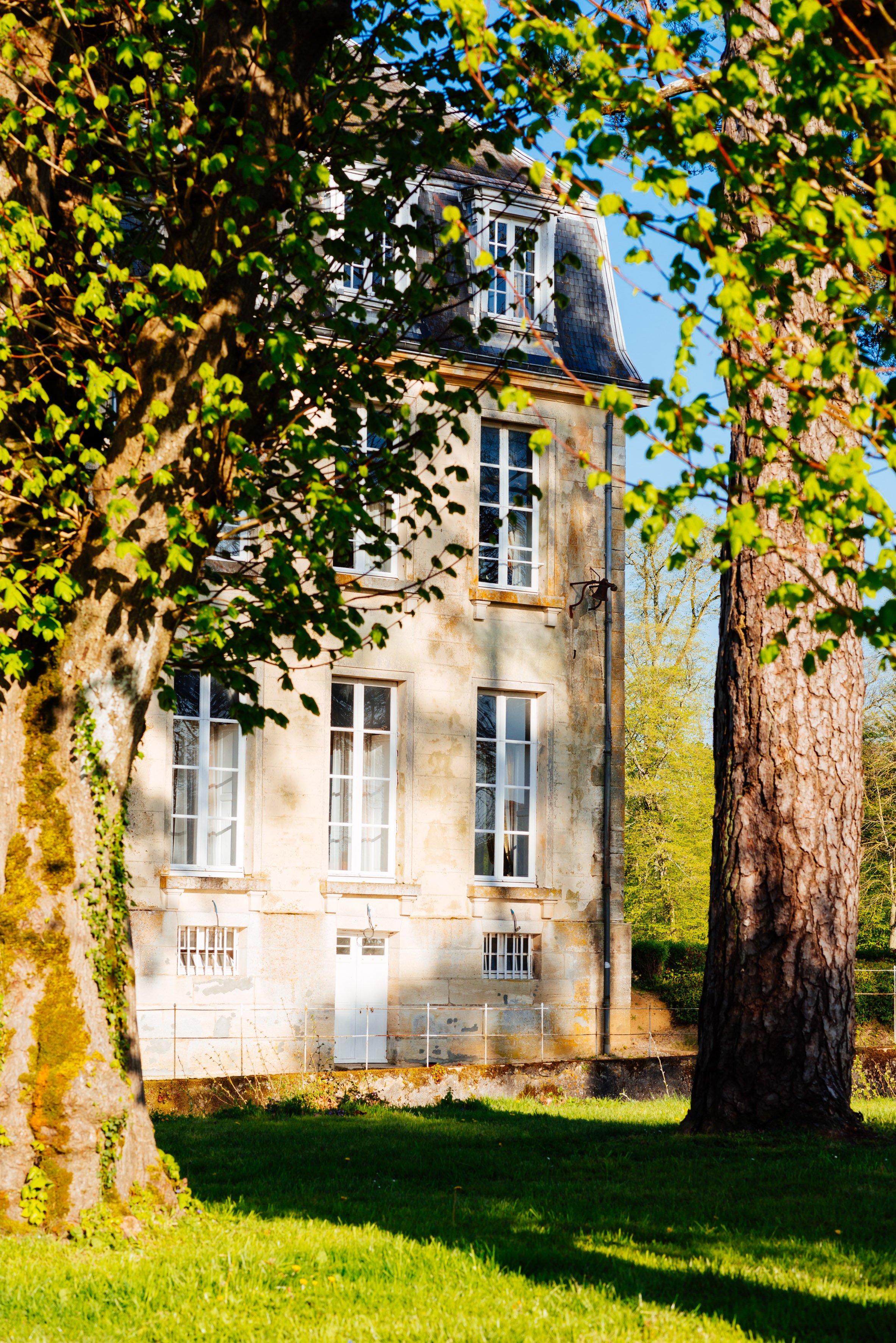 The west wing of Chateau de Courtomer viewed through the Sycamore trees. To rent for weddings, retreats and other events.