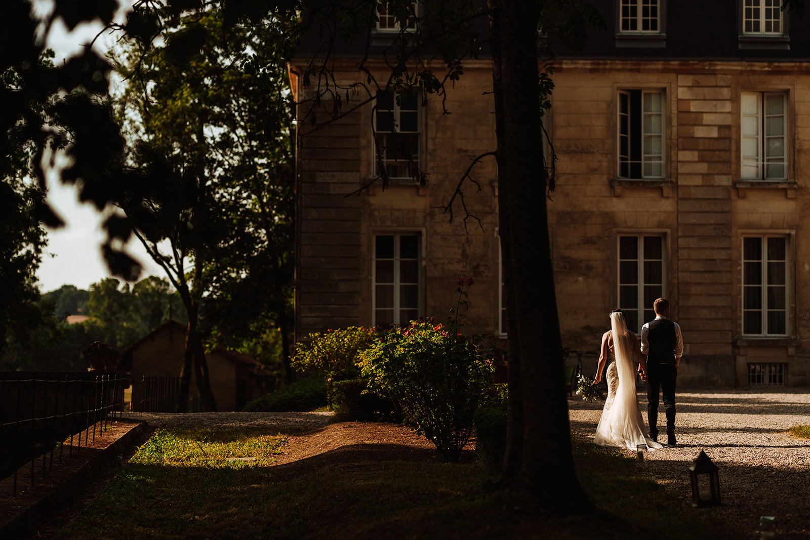A bride and groom at twilight  in front of Chateau de Courtomer near Paris .