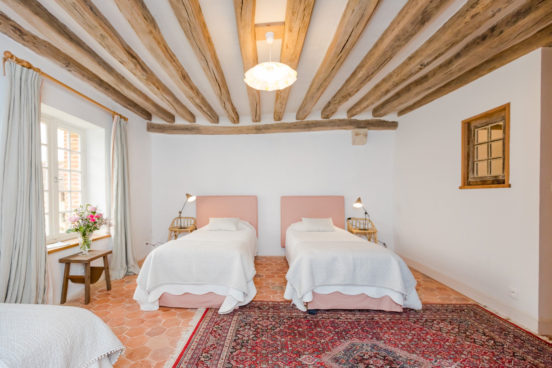 A twin bedded country bedroom with wooden beams available to rent in the farmhouse.