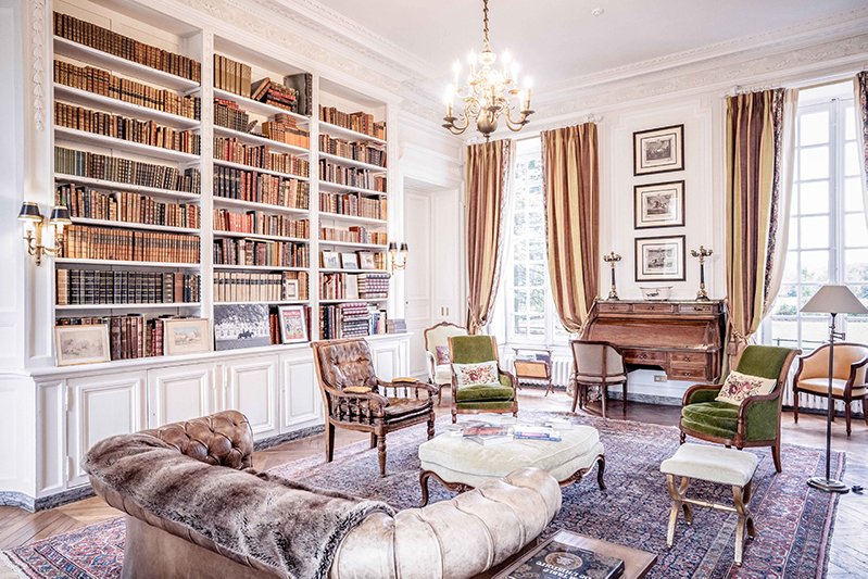 The  library with a fireplace, perfect for relaxing and reading  in a French castle near Paris.