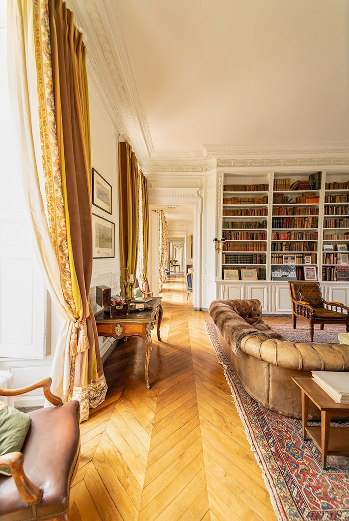 A view from the library down the enfilade Inside Chateau de Courtomer, showing the warm wood floors and window dressings.