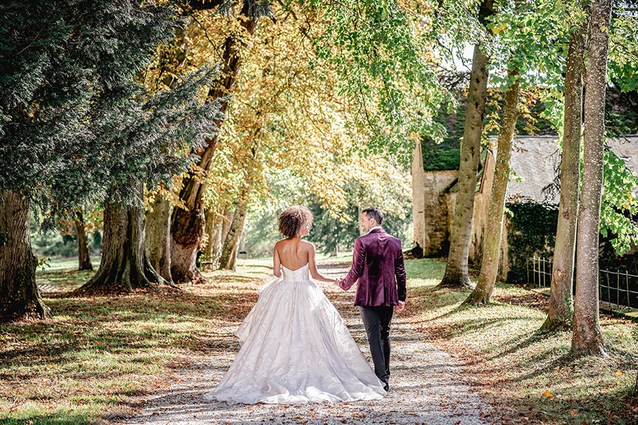 A bride and groom strolling through the enchanting woods near a chateau in France.