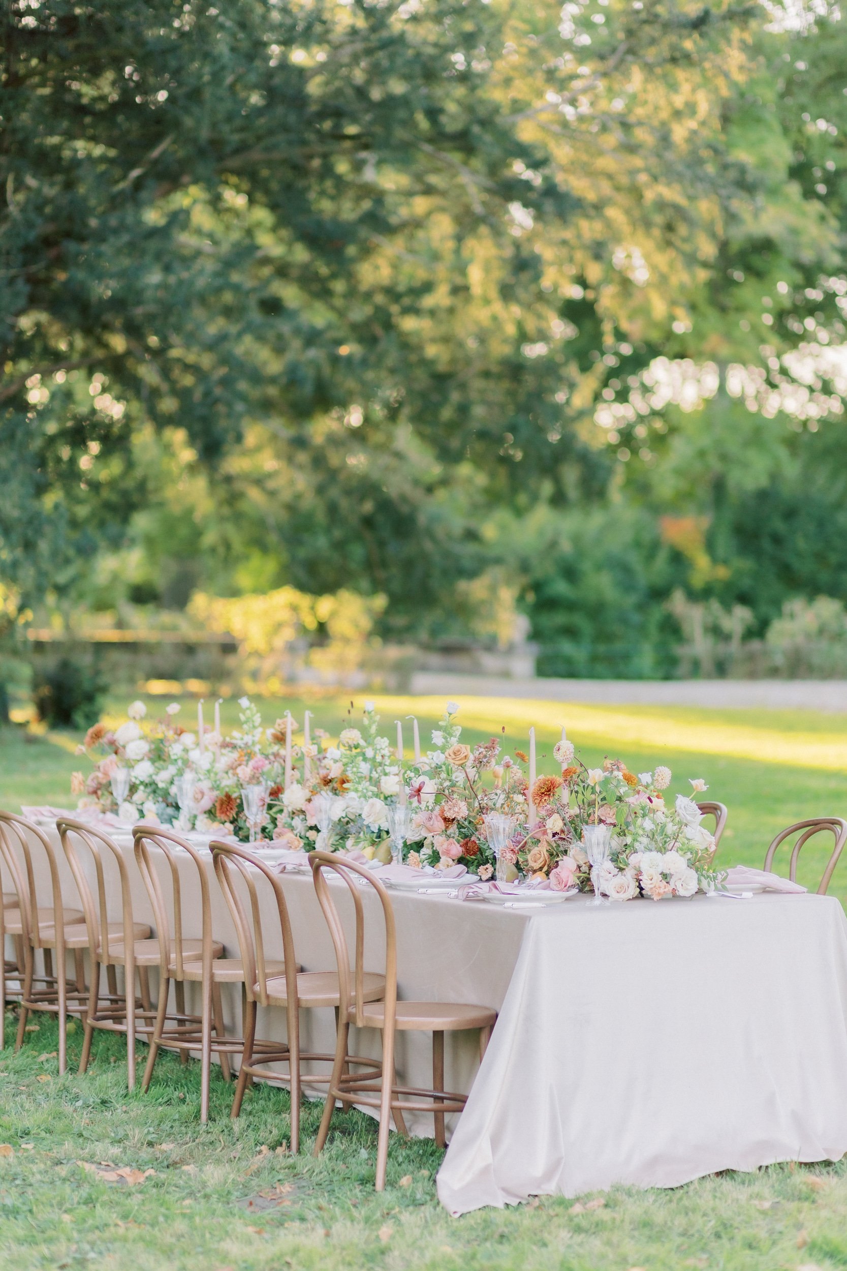 A table set for an alfresco wedding breakfast in the grounds of Chateau de Courtomer, a chateau wedding venue in France.