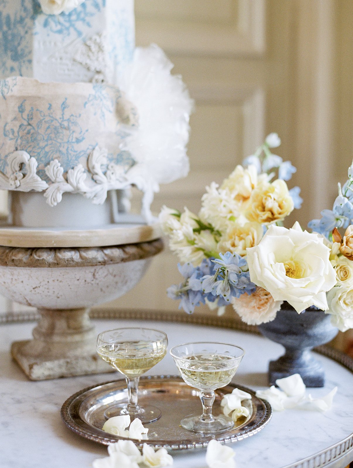 A blue and white  wedding cake on a table at a French chateau wedding.