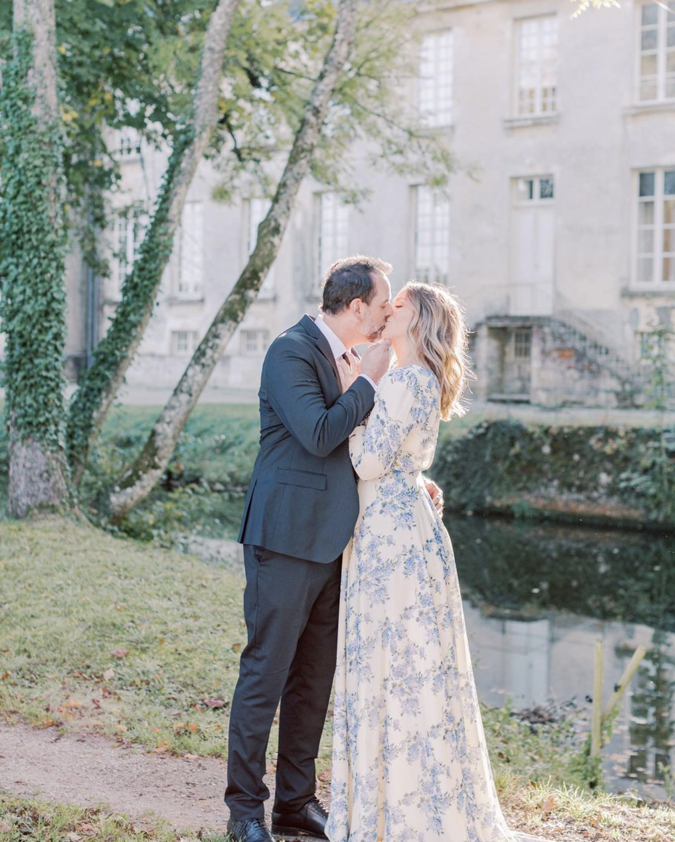 A couple kissing in front of Chateau de Courtomer, a French chateau wedding venue ideal for elopements.
