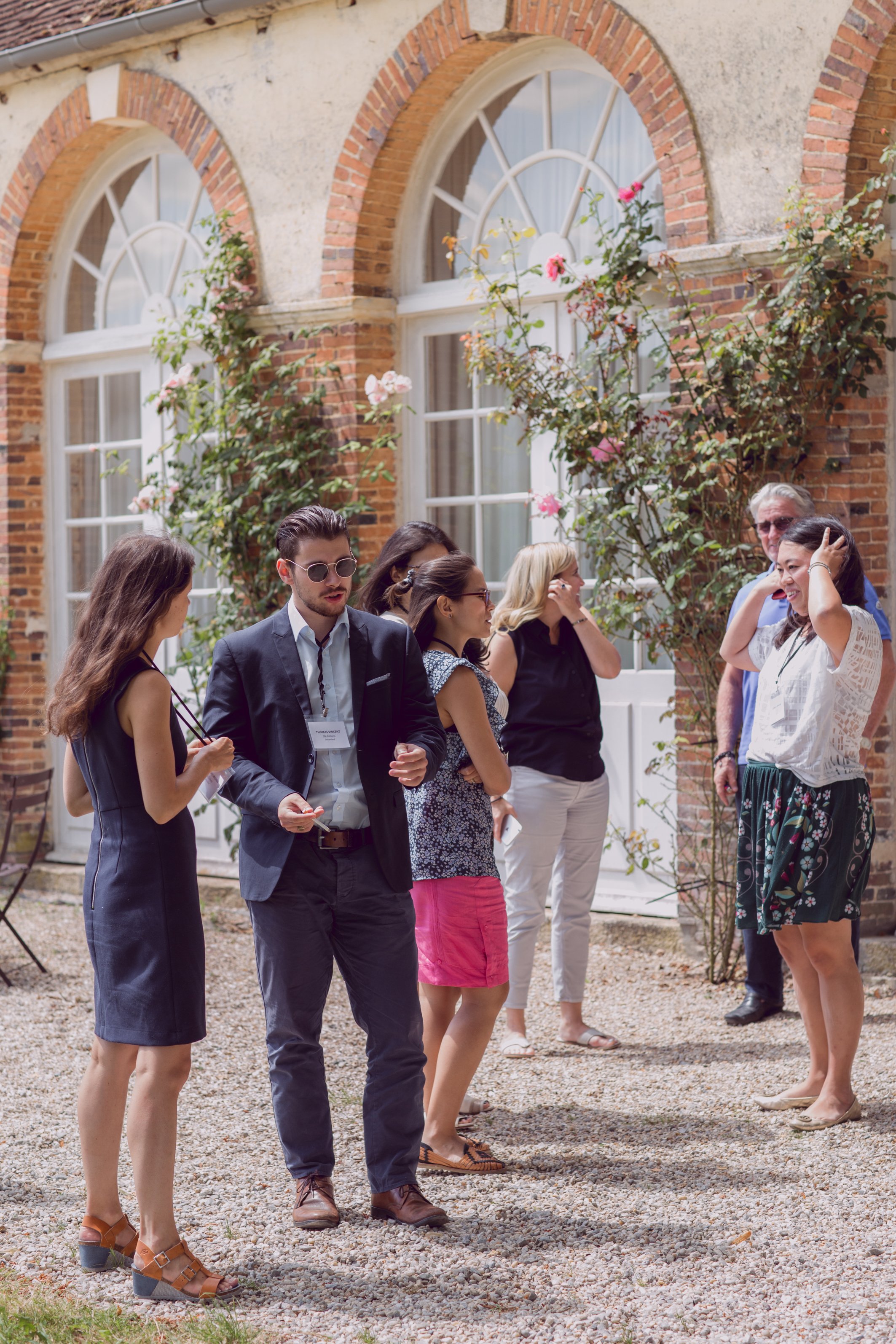 A group of people standing in front of the Orangerie, a perfect venue for retreats, corporate events, parties and weddings.