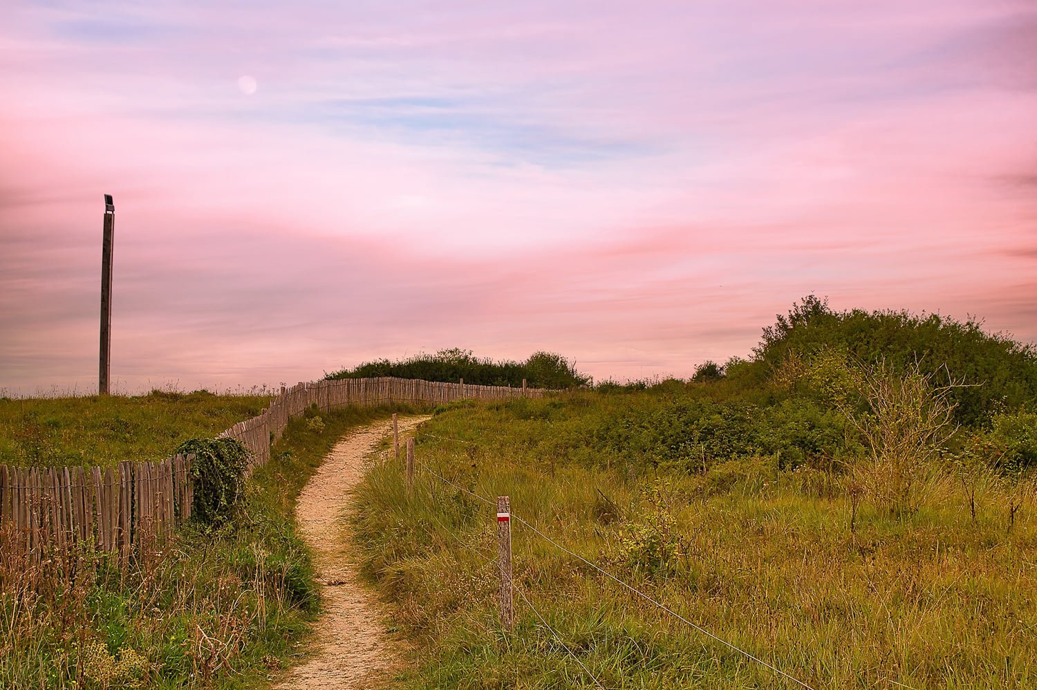 A beach path leads over the dunes in Normandy France.