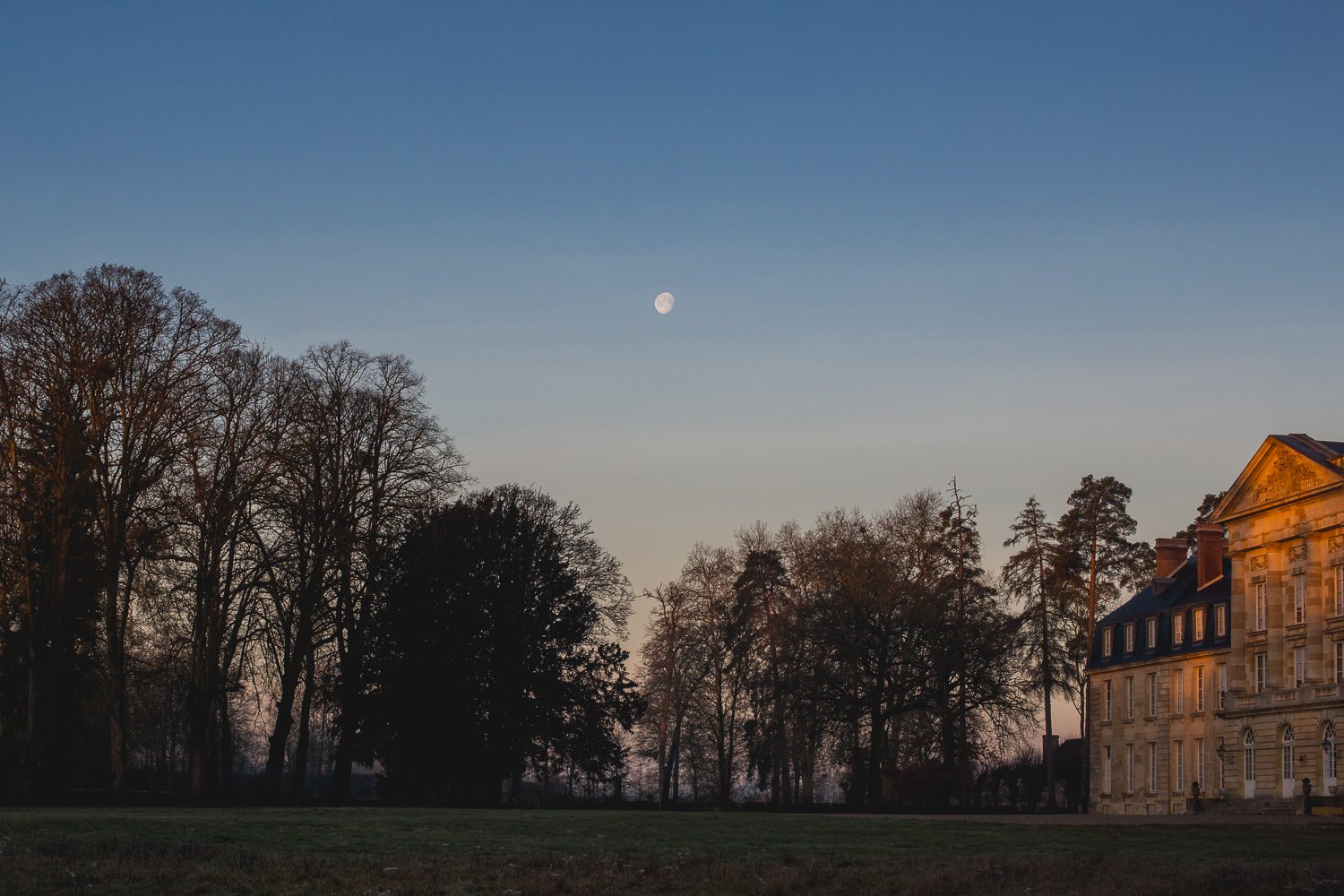 The moon rises over Chateau de Courtomer at dusk during a weekend getaway in France.