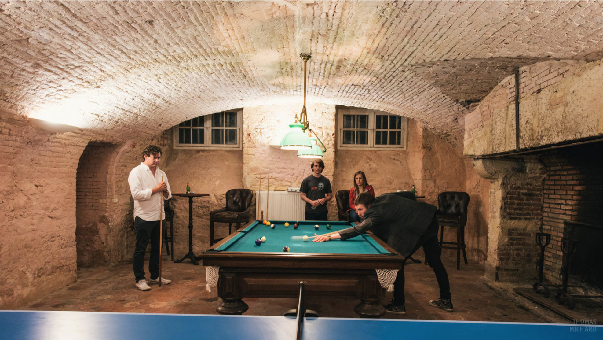 A group of people playing pool in the games room during a weekend break at Chateau de Courtomer in Normandy, France.