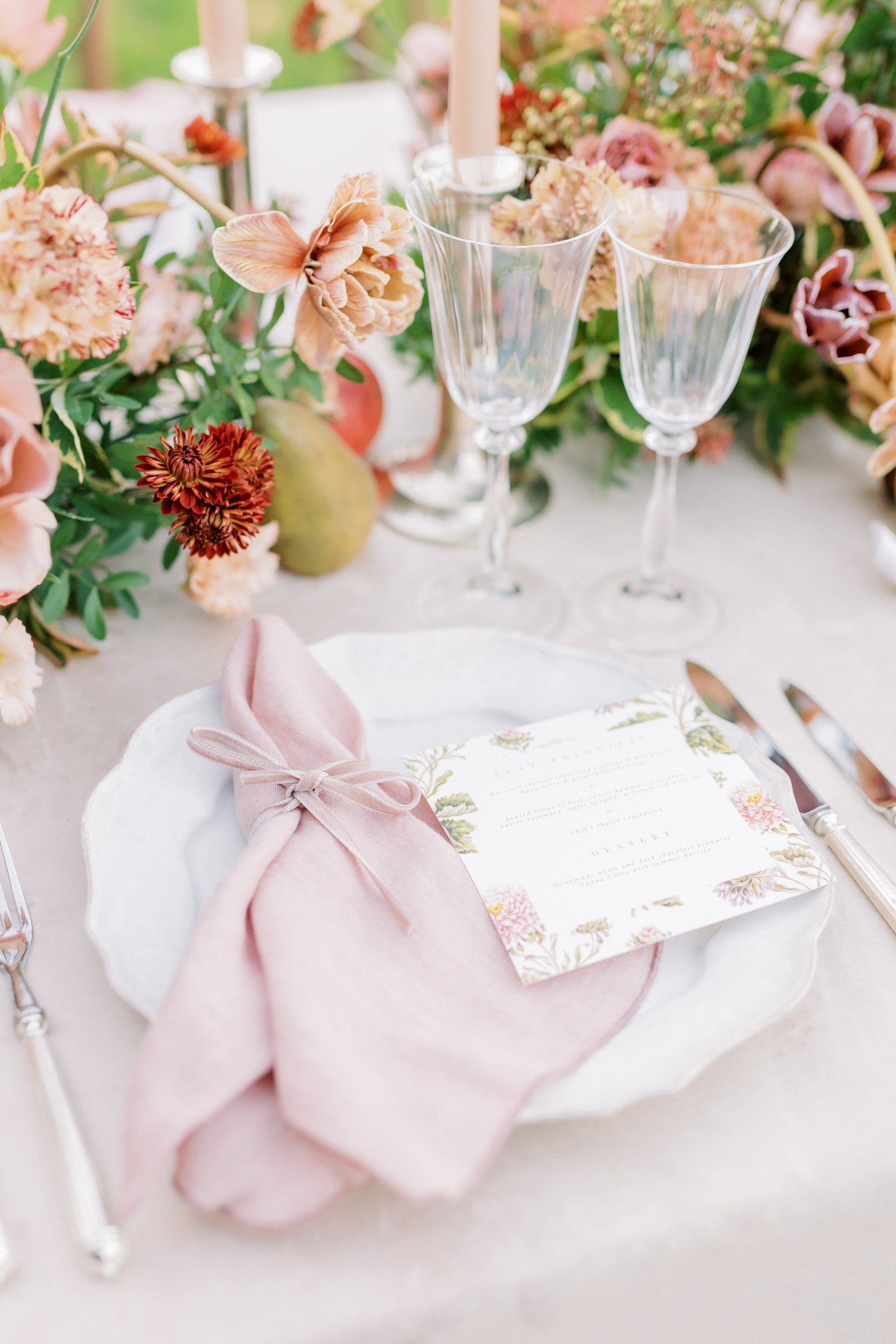 A wedding table setting with pink napkins and pretty flowers at Chateau de Courtomer.