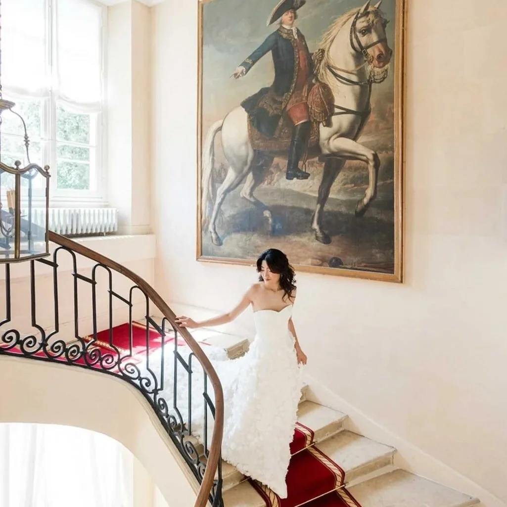 Bride walking down the red carpet steps in the Chateau