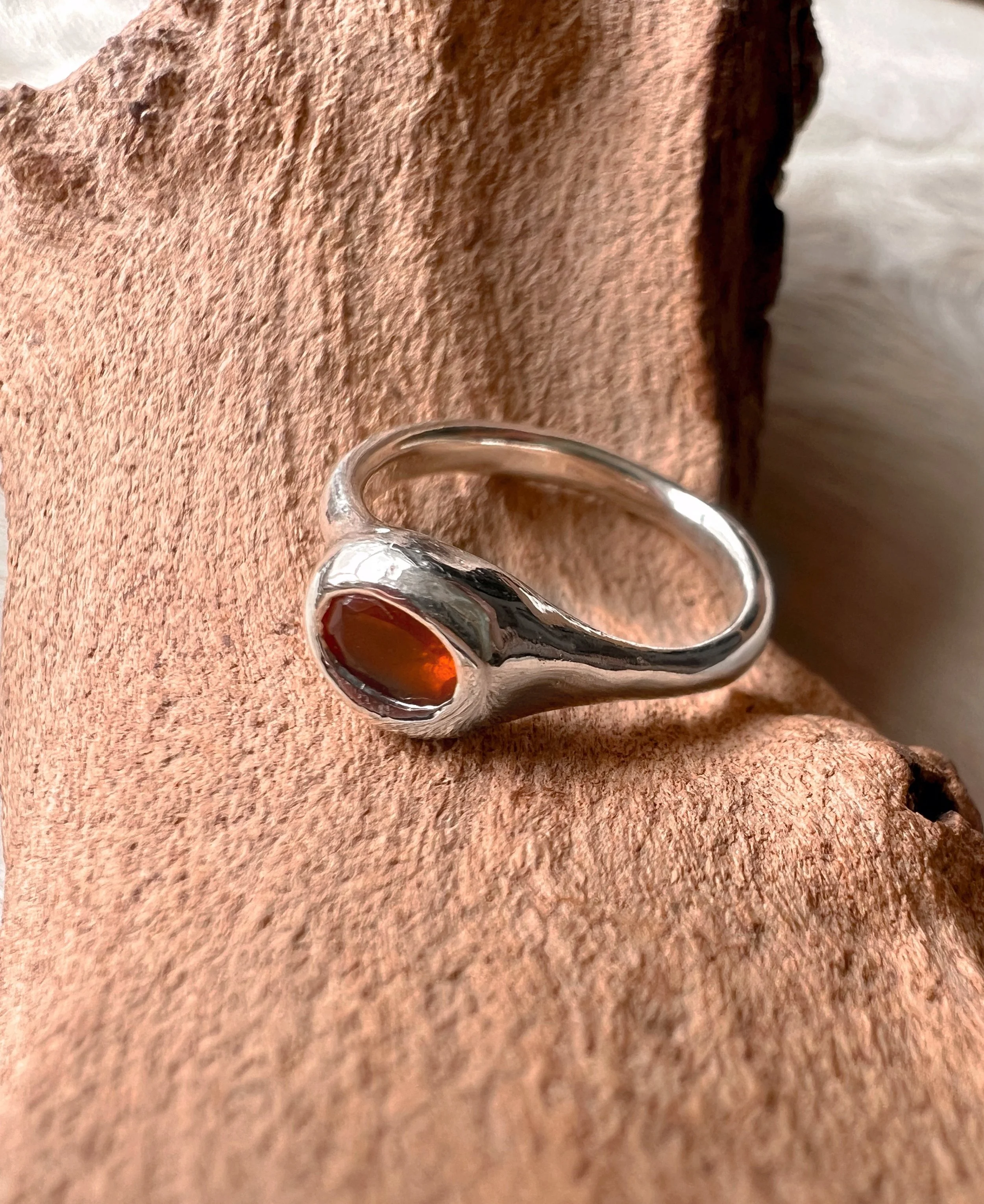 Signet-style sterling silver ring with a subtle, hand-carved texture and topped with an orange fire opal.