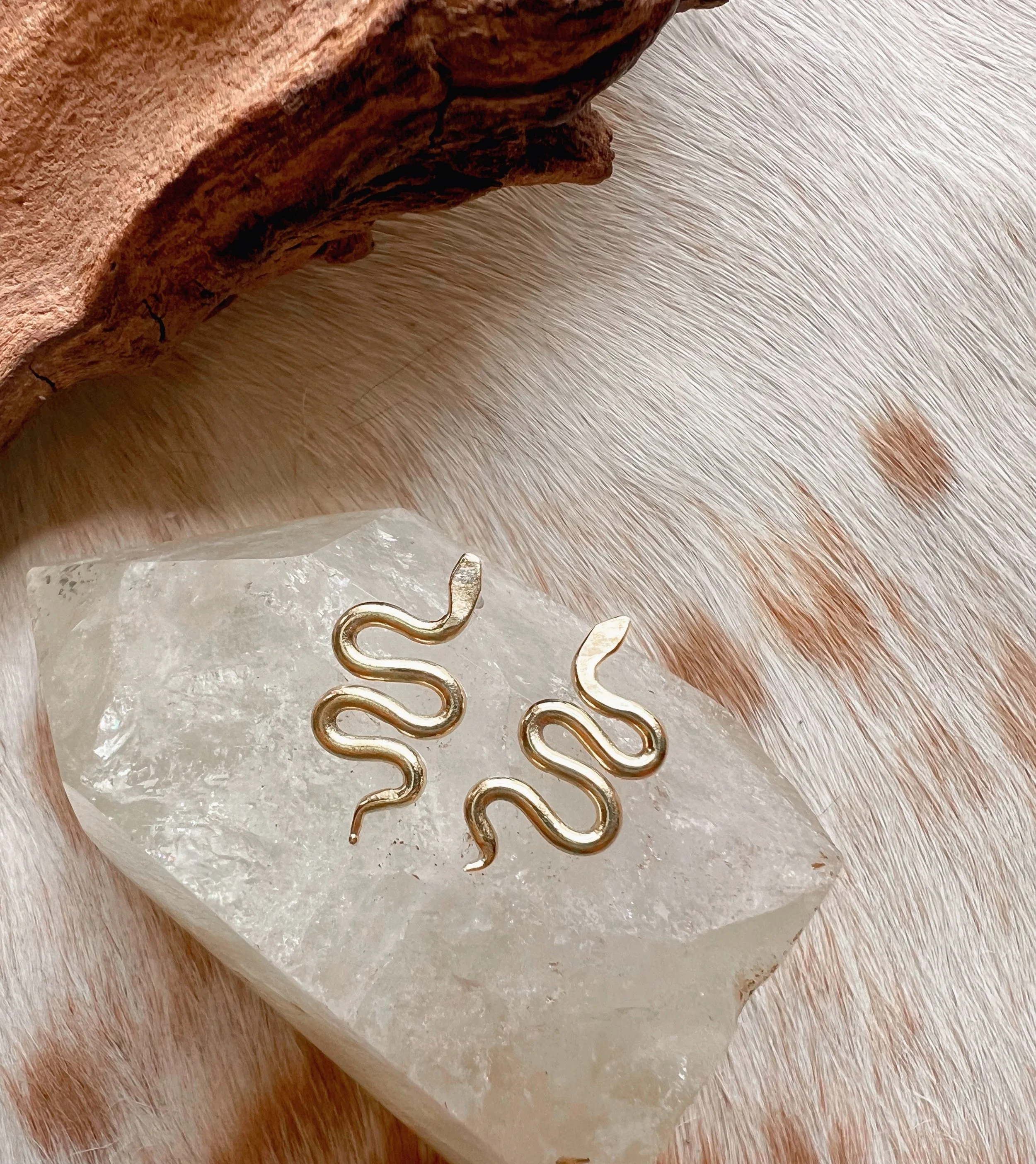 A pair of snake earrings made of brass with sterling silver posts and backs