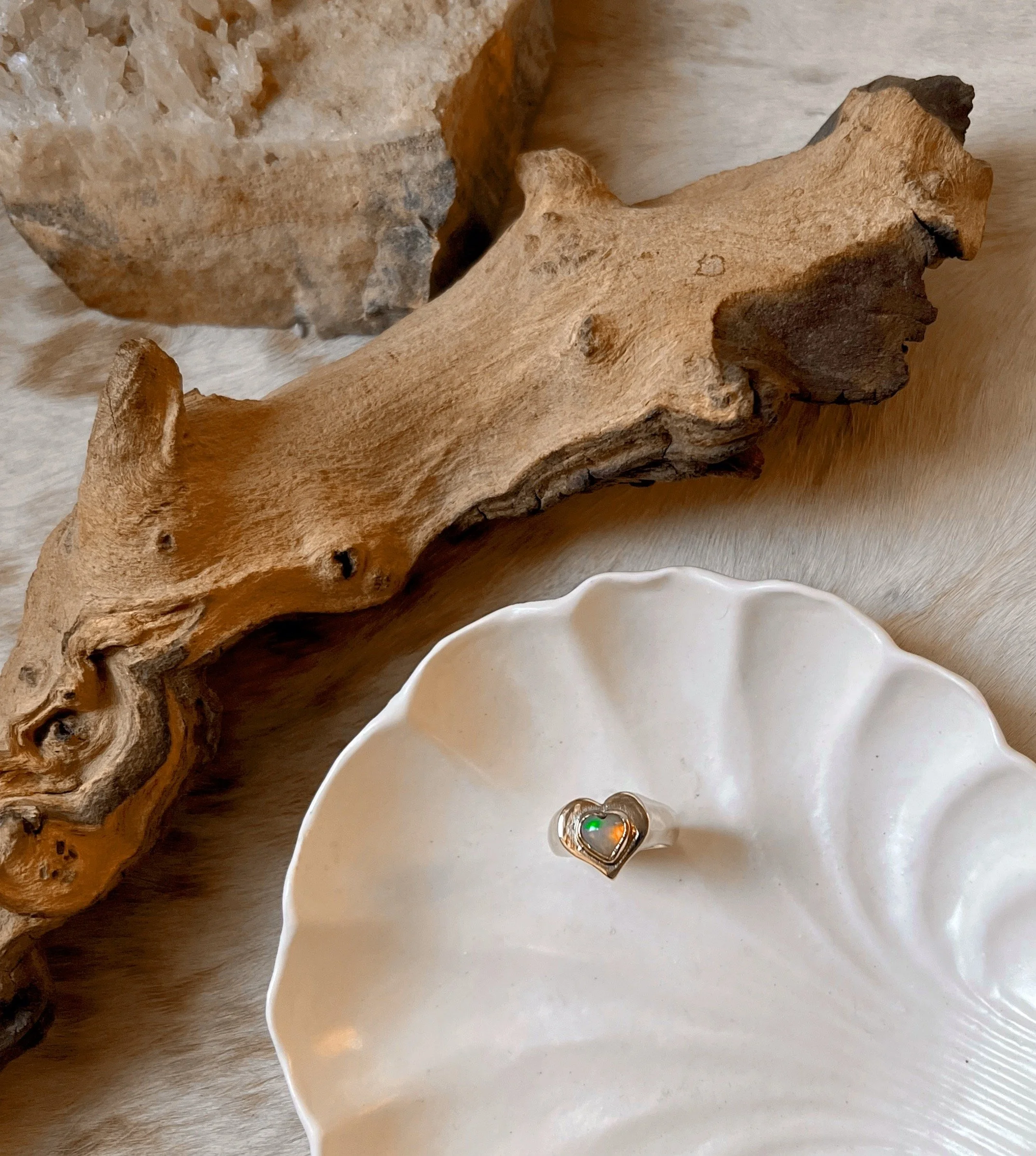 Chunky brass ring featuring a delicate heart-shaped Ethiopian opal.