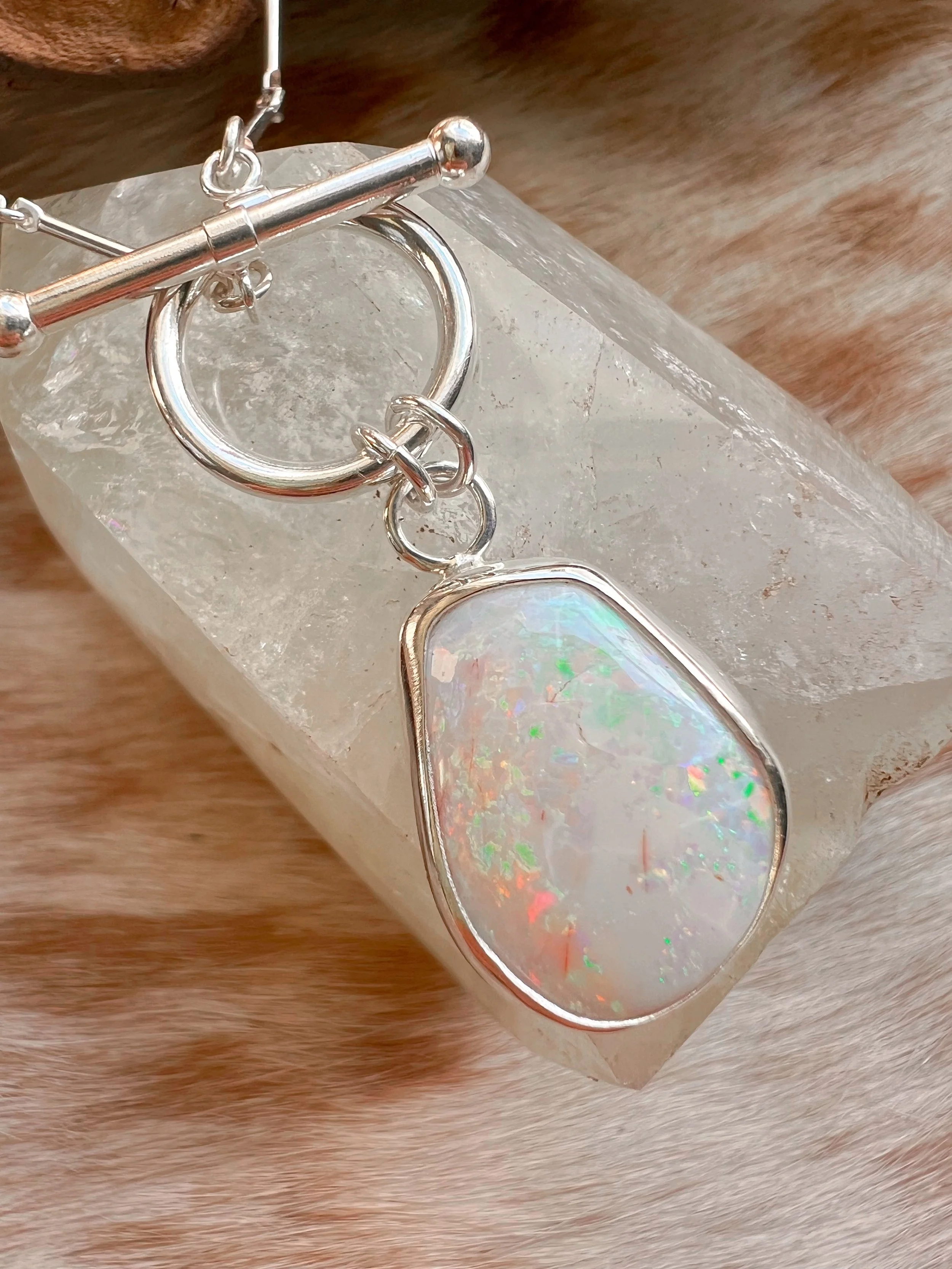 A smooth, natural gemstone cabochon set in a Sterling silver pendant on a sterling silver chain