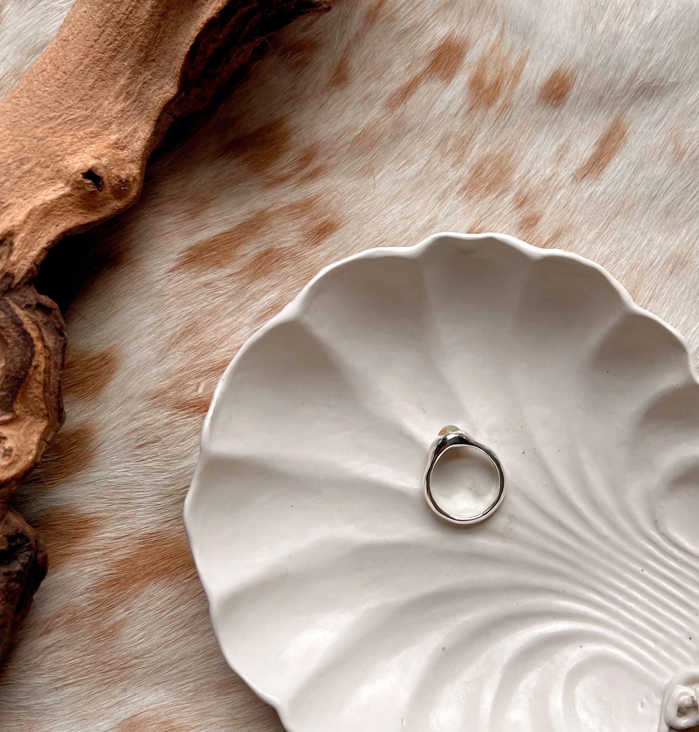 Signet-style sterling silver ring with a subtle, hand-carved texture and topped with an opal.