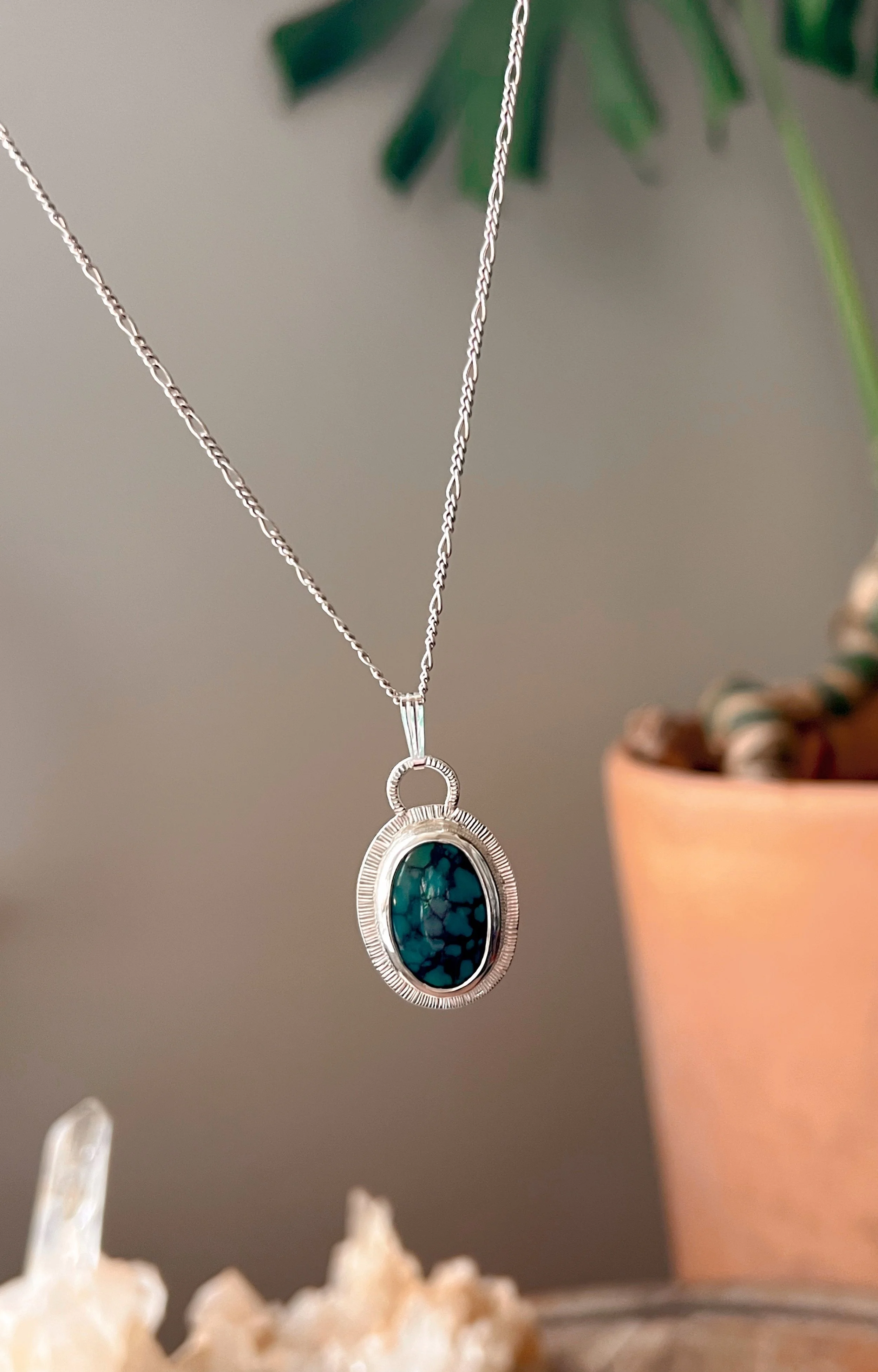 A smooth, natural gemstone cabochon set in a Sterling silver pendant on a sterling silver chain