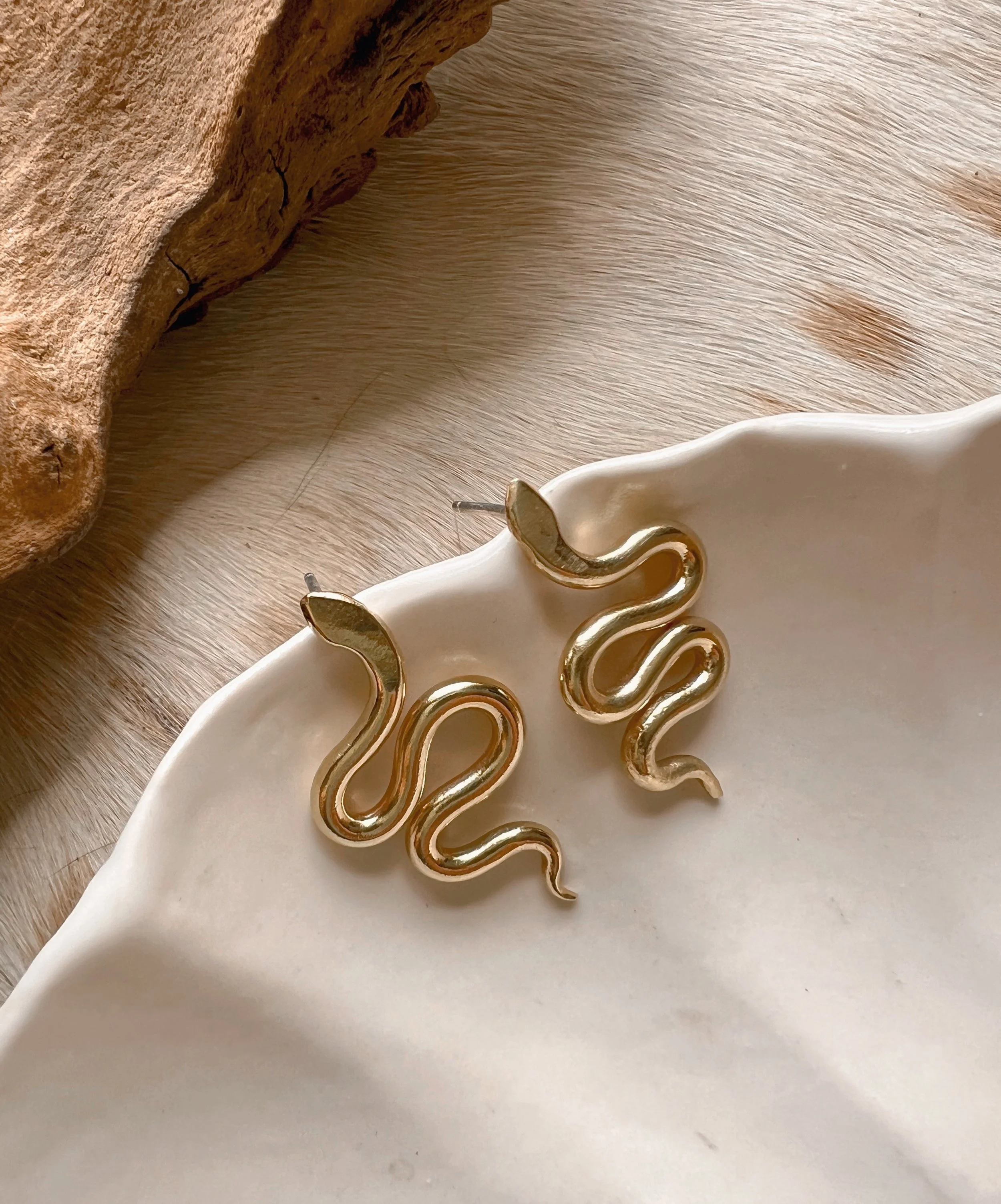 A pair of snake earrings made of brass with sterling silver posts and backs