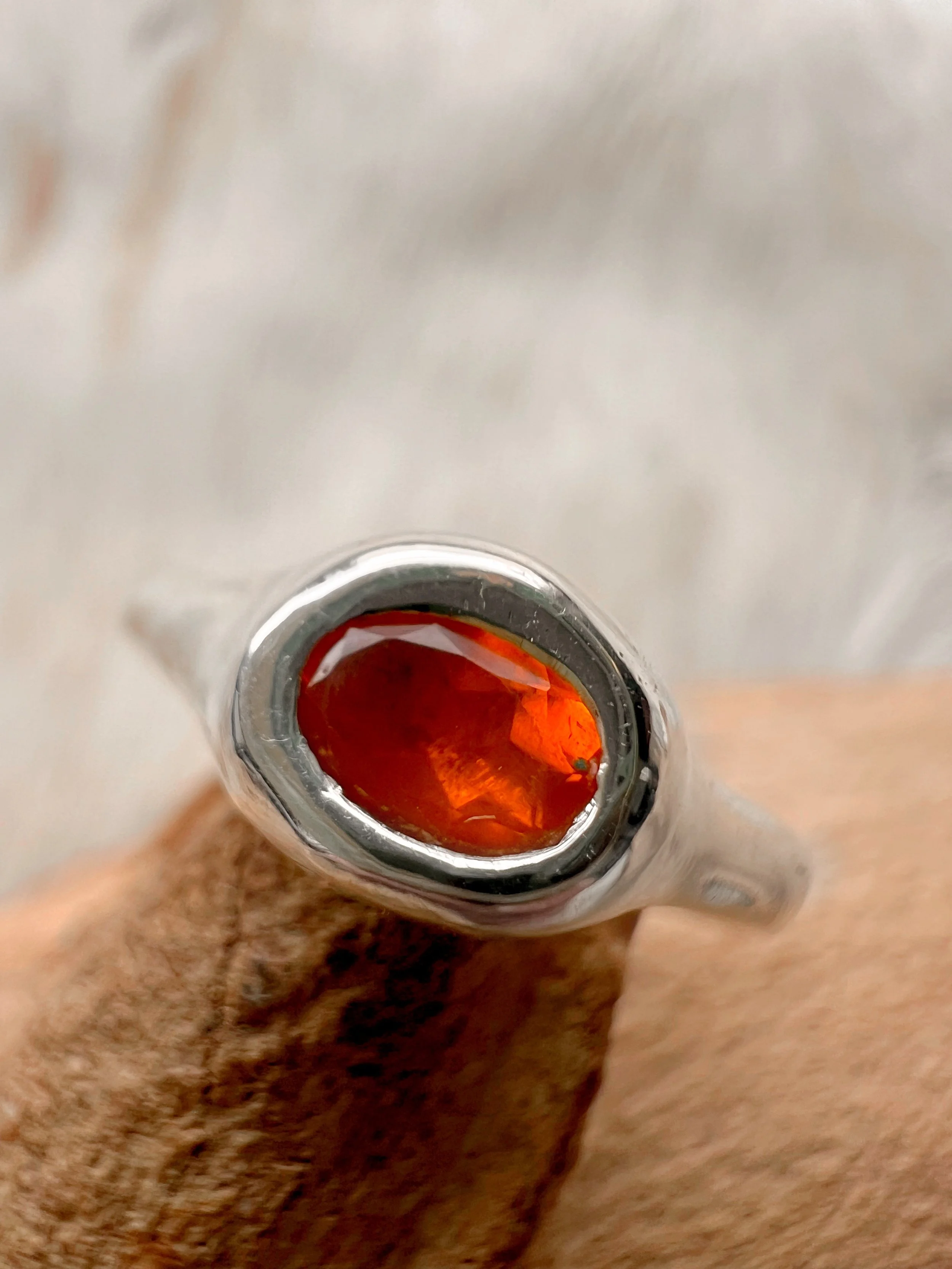 Signet-style sterling silver ring with a subtle, hand-carved texture and topped with an orange fire opal.