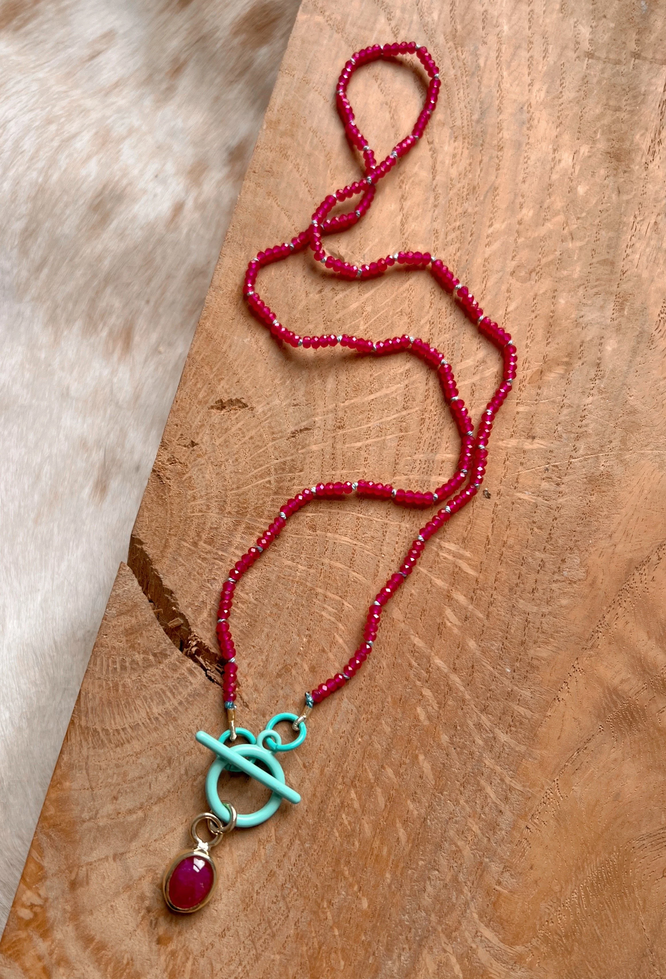 beaded ruby necklace, with a larger pink ruby in the center