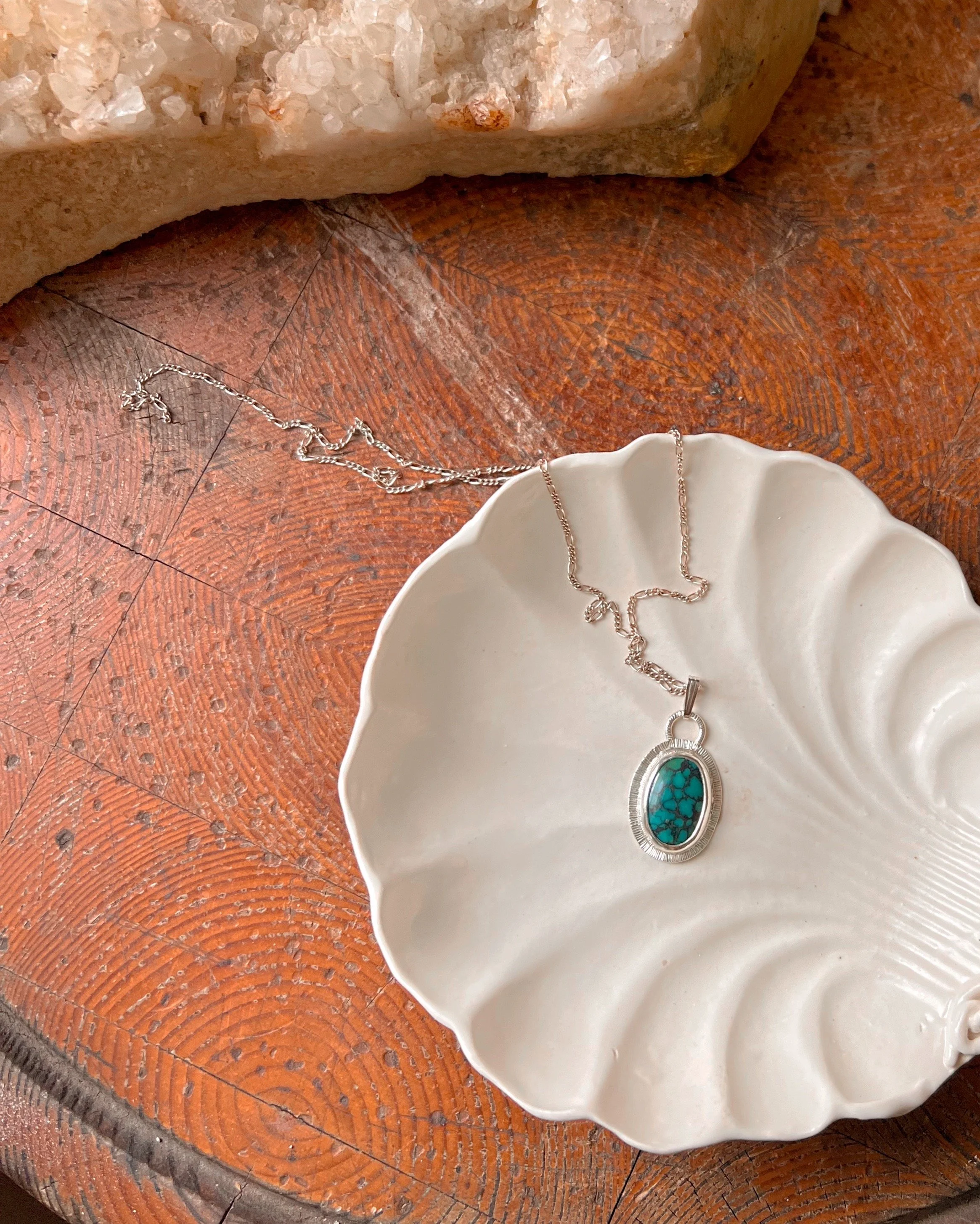 A smooth, natural gemstone cabochon set in a Sterling silver pendant on a sterling silver chain