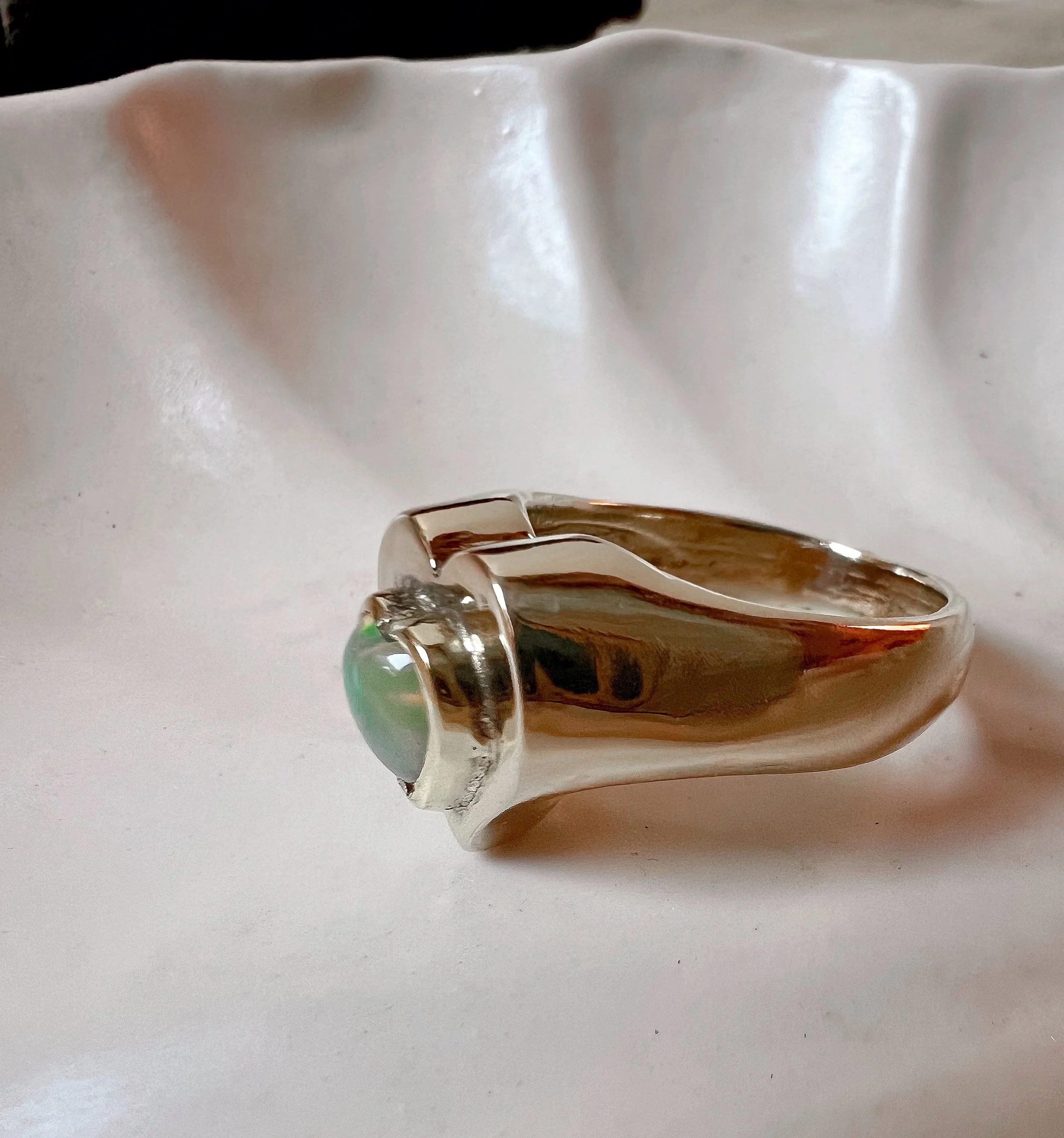 Chunky brass ring featuring a delicate heart-shaped Ethiopian opal.