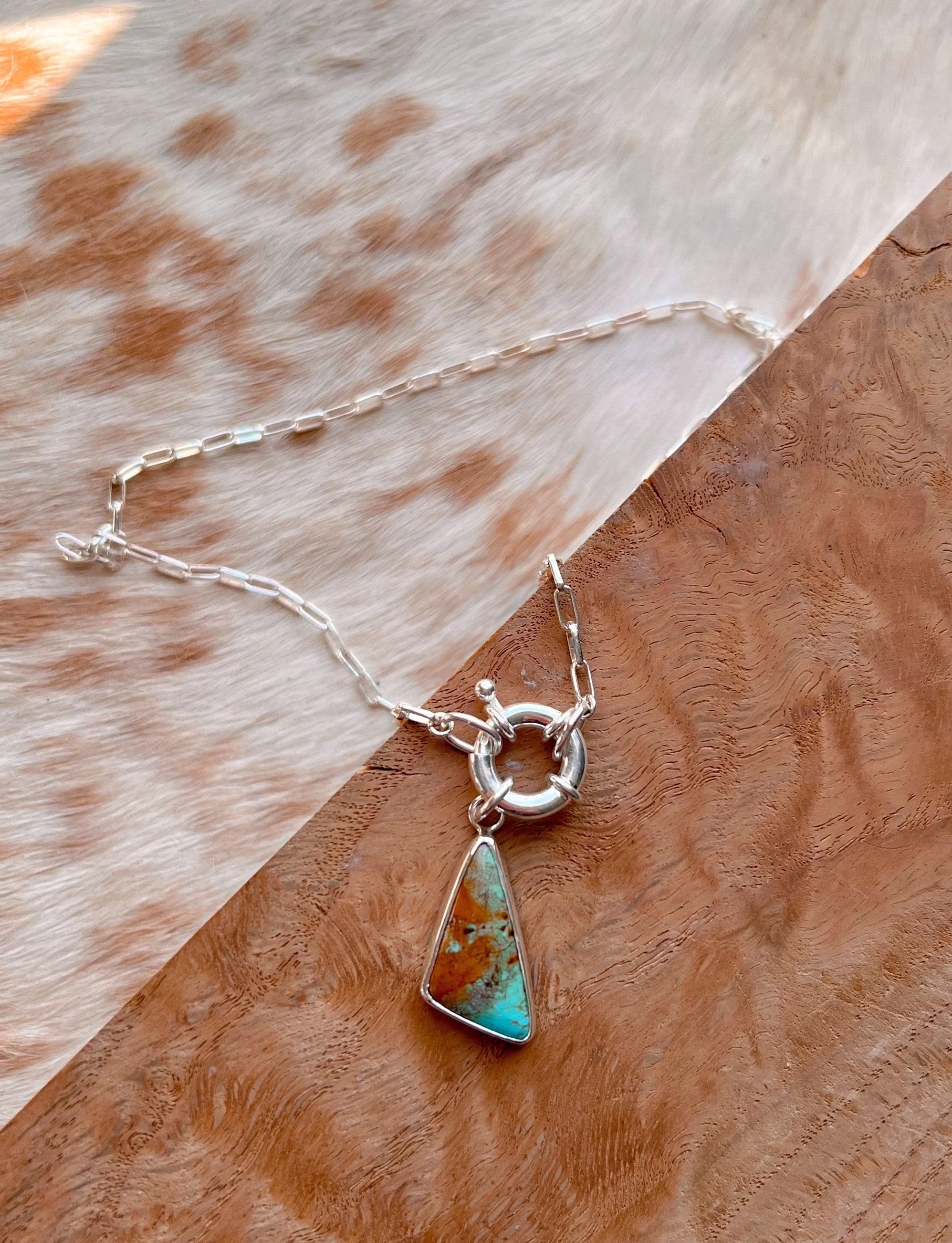 A smooth, natural gemstone cabochon set in a Sterling silver pendant on a sterling silver chain