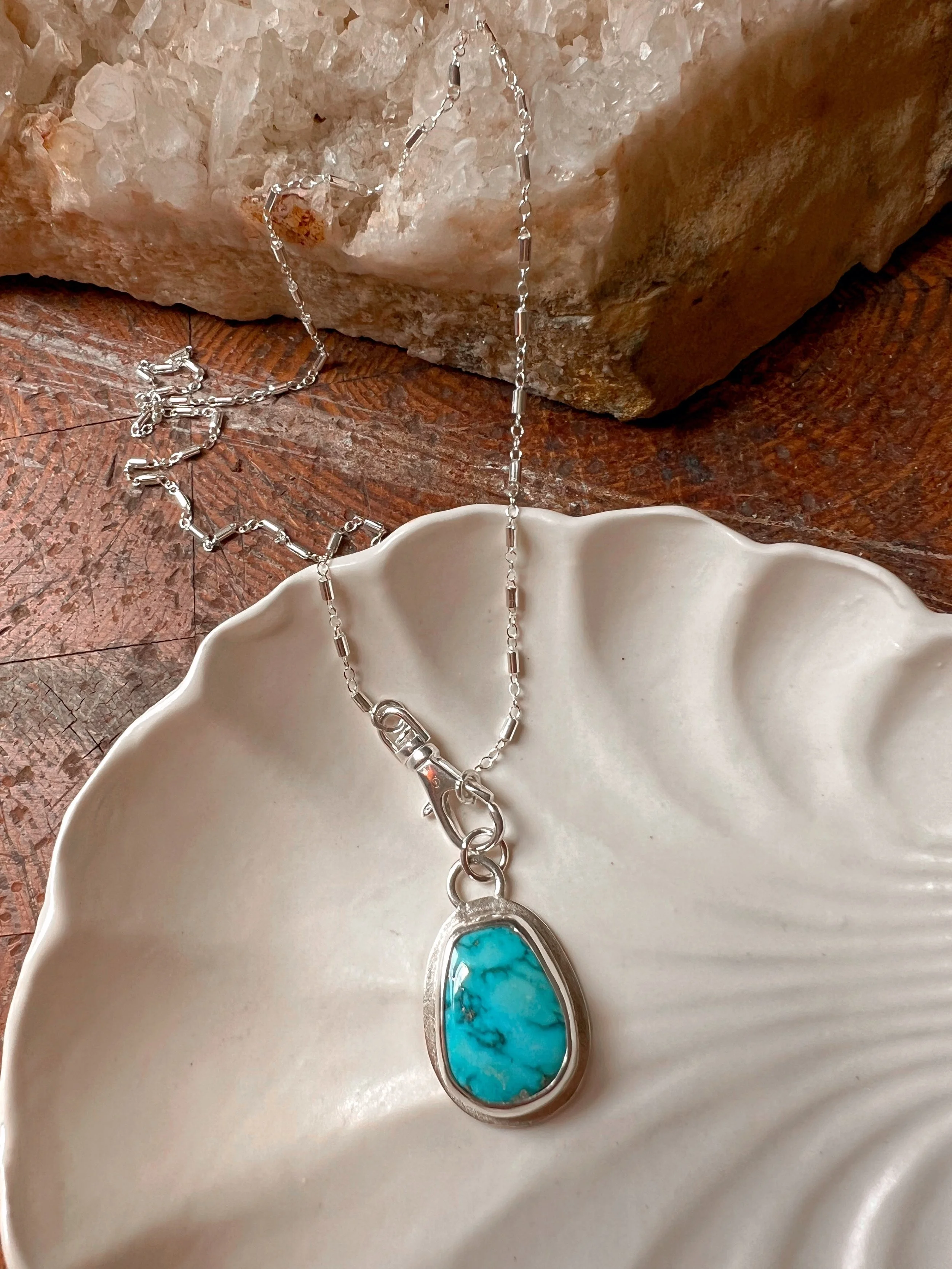 A smooth, natural gemstone cabochon set in a Sterling silver pendant on a sterling silver chain
