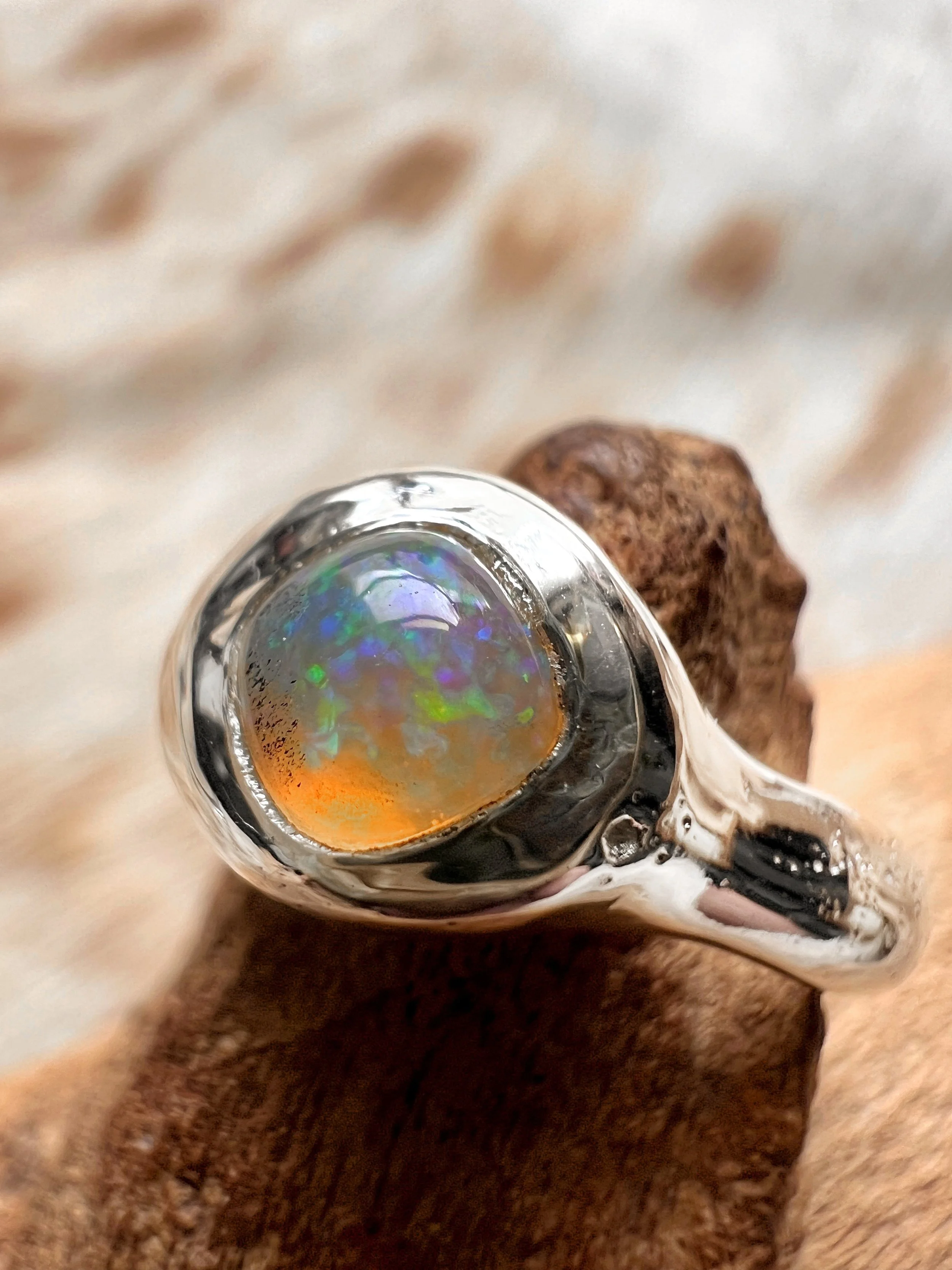 Signet-style sterling silver ring with a subtle, hand-carved texture and topped with an opal.