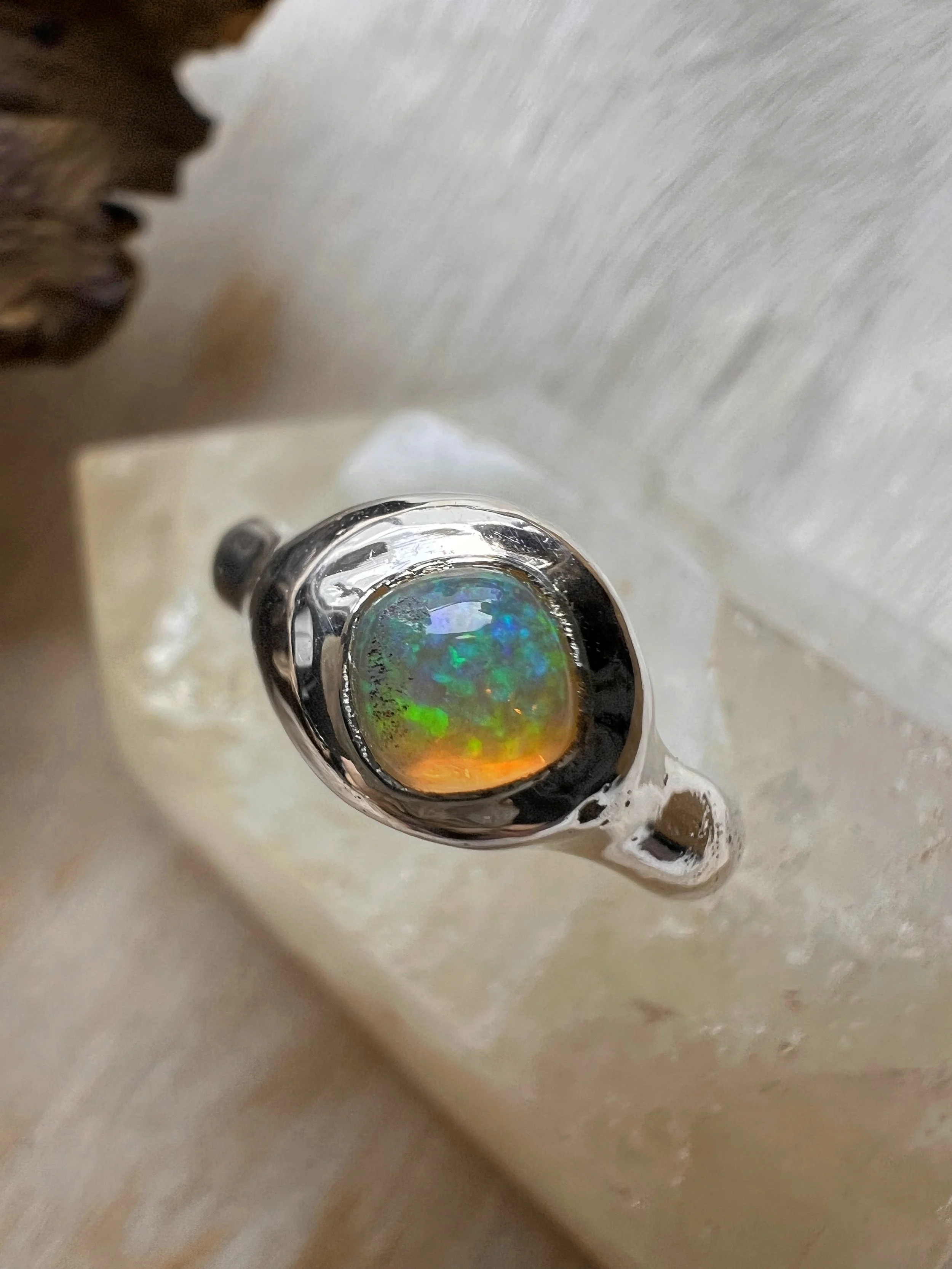 Signet-style sterling silver ring with a subtle, hand-carved texture and topped with an opal.