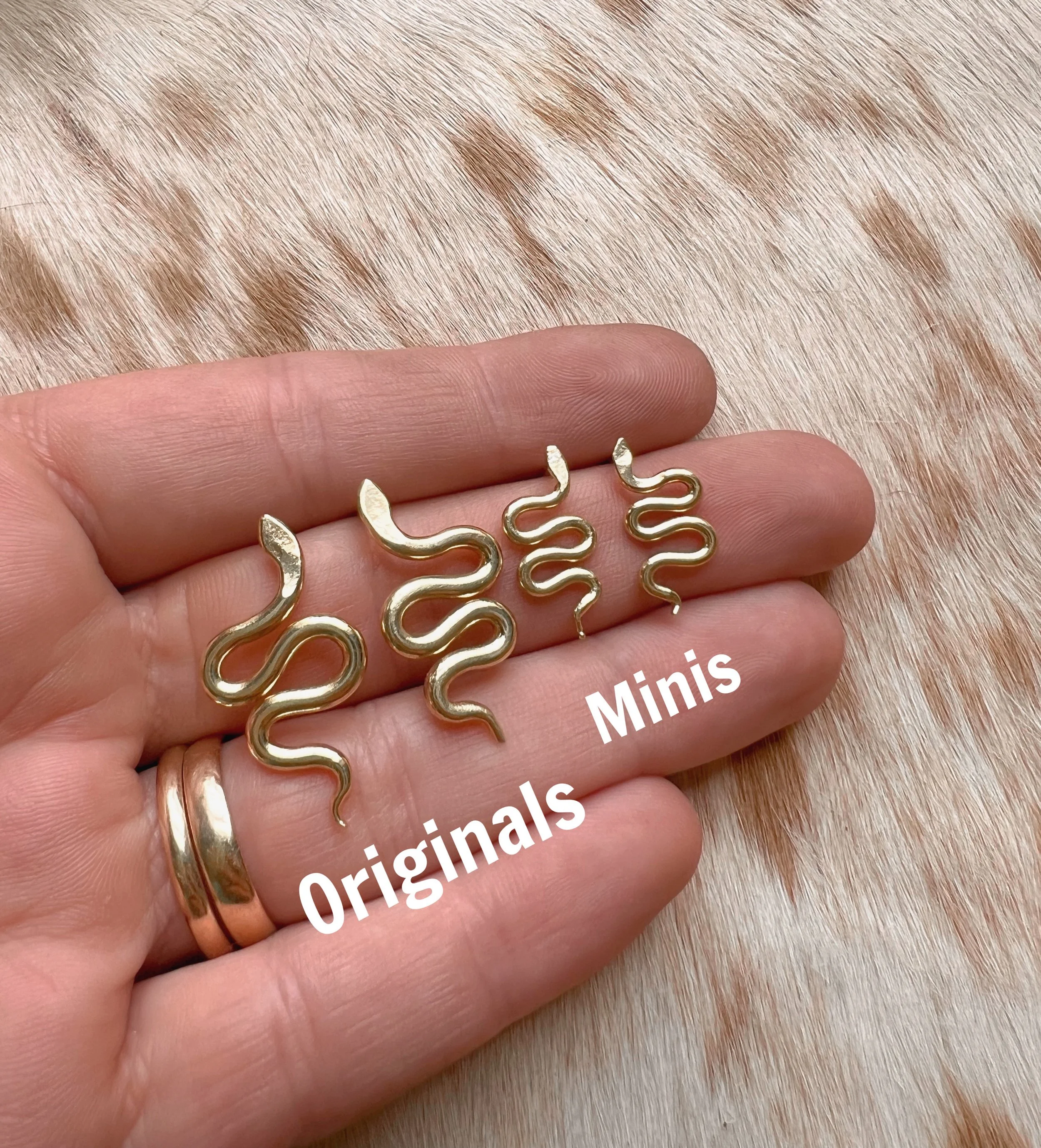 A pair of snake earrings made of brass with sterling silver posts and backs