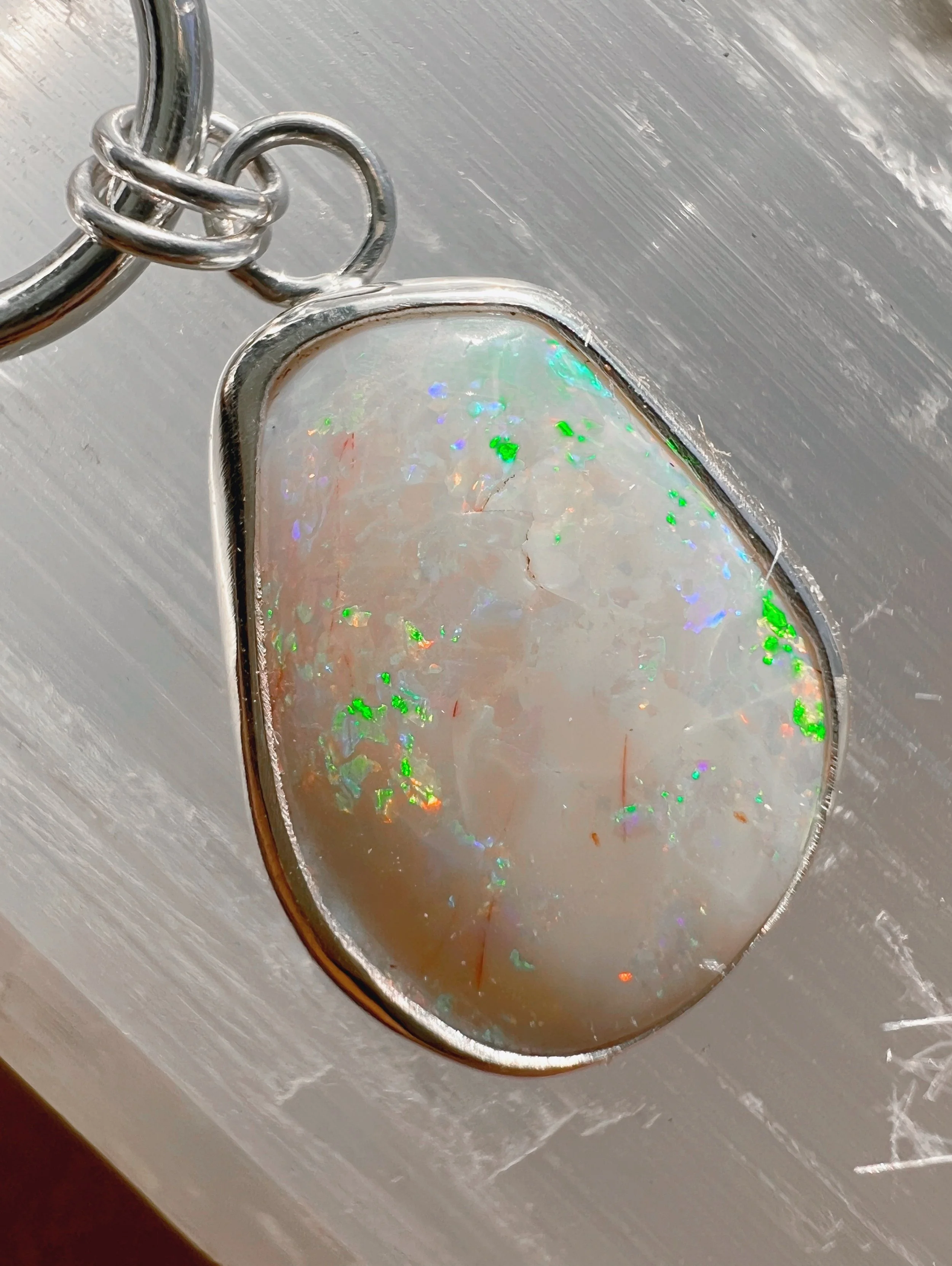 A smooth, natural gemstone cabochon set in a Sterling silver pendant on a sterling silver chain