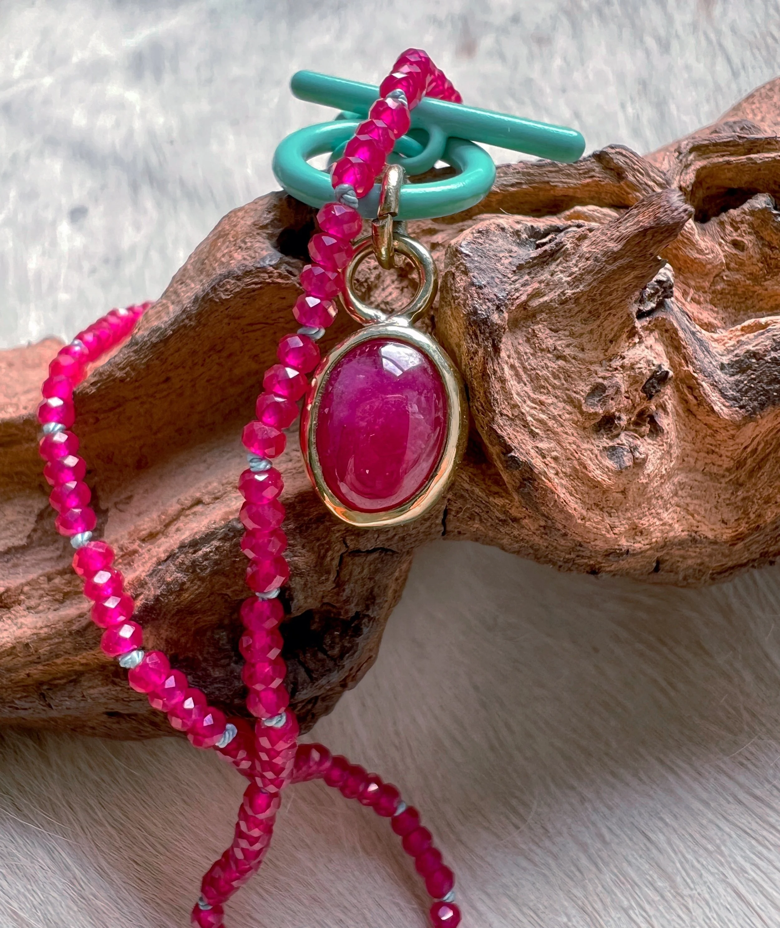 beaded ruby necklace, with a larger pink ruby in the center
