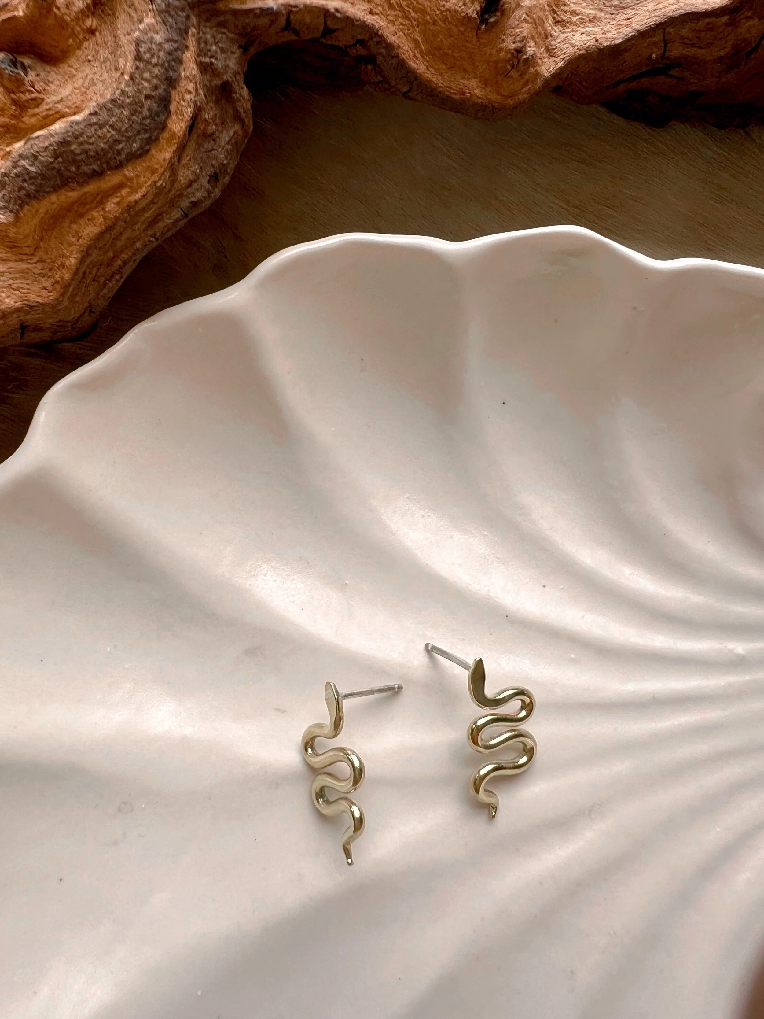 A pair of snake earrings made of brass with sterling silver posts and backs