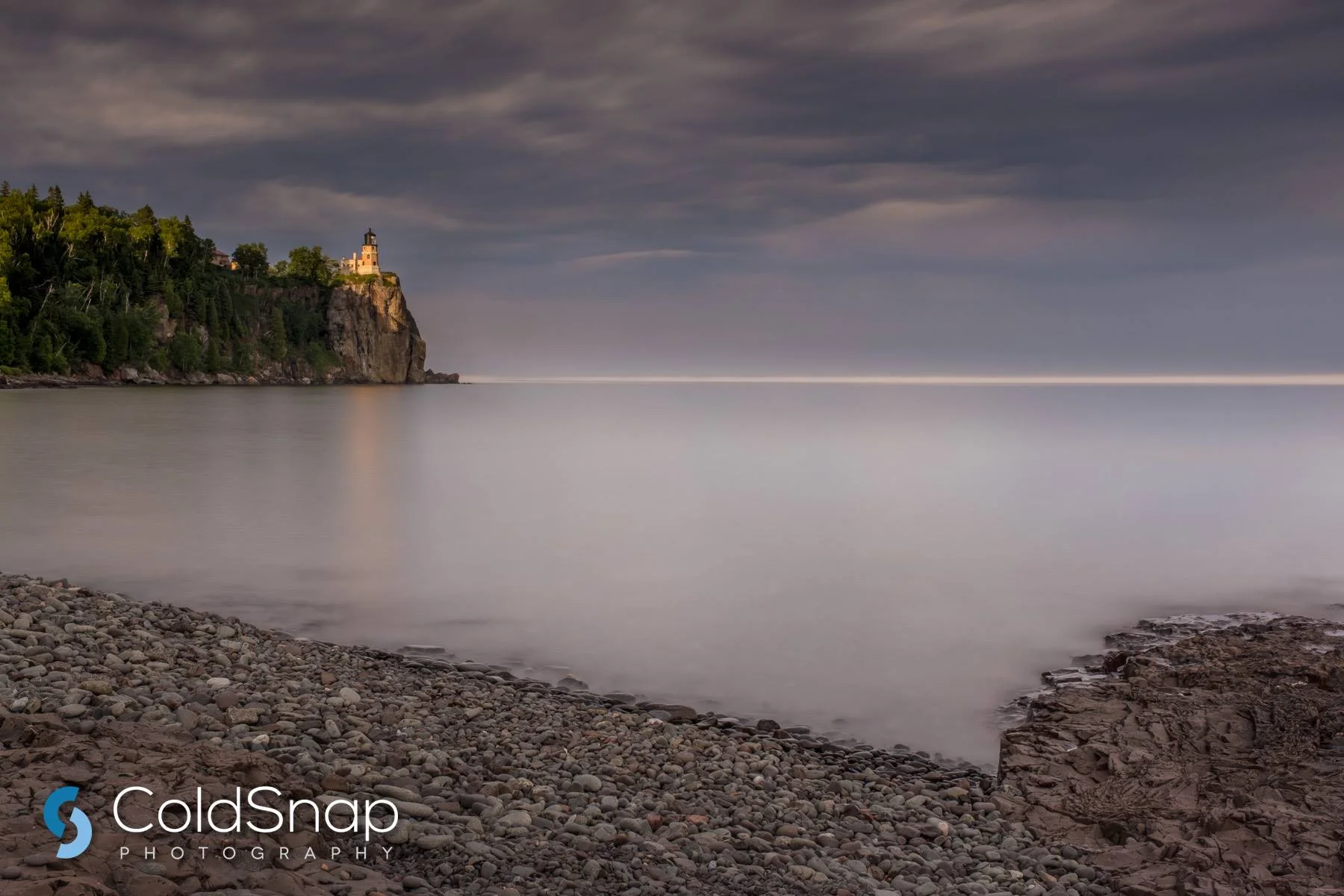 Split Rock Lighthouse and Pebble Beach at Sunset / John Gregor