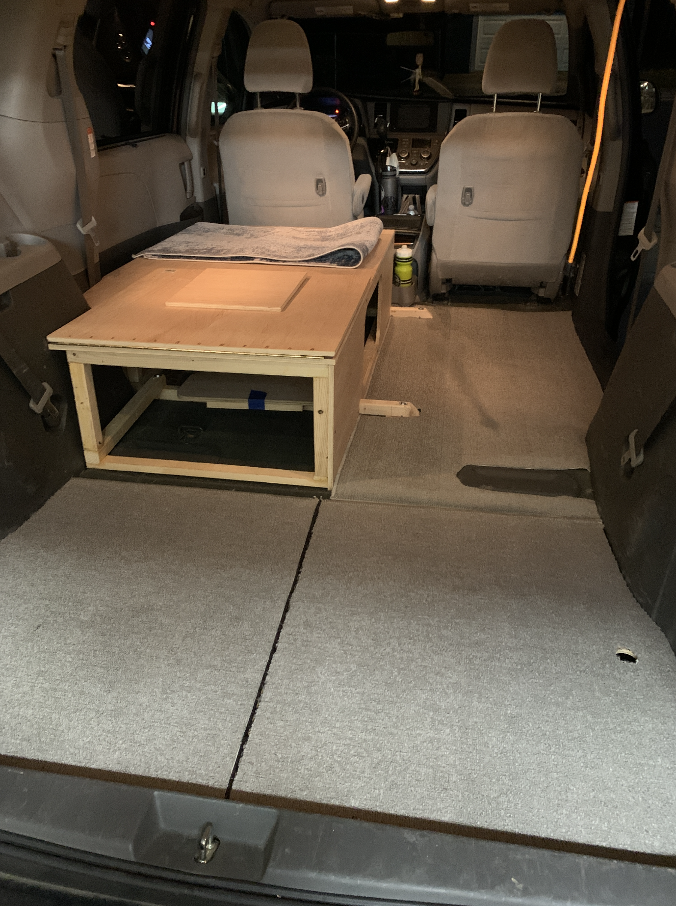 Interior of the van after removing the seats and creating a sleeping platform with storage.