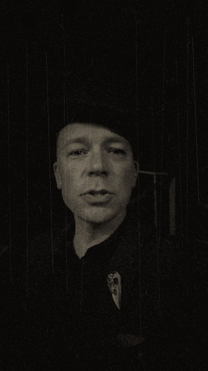 Nolan in a bowler hat, half in shadow