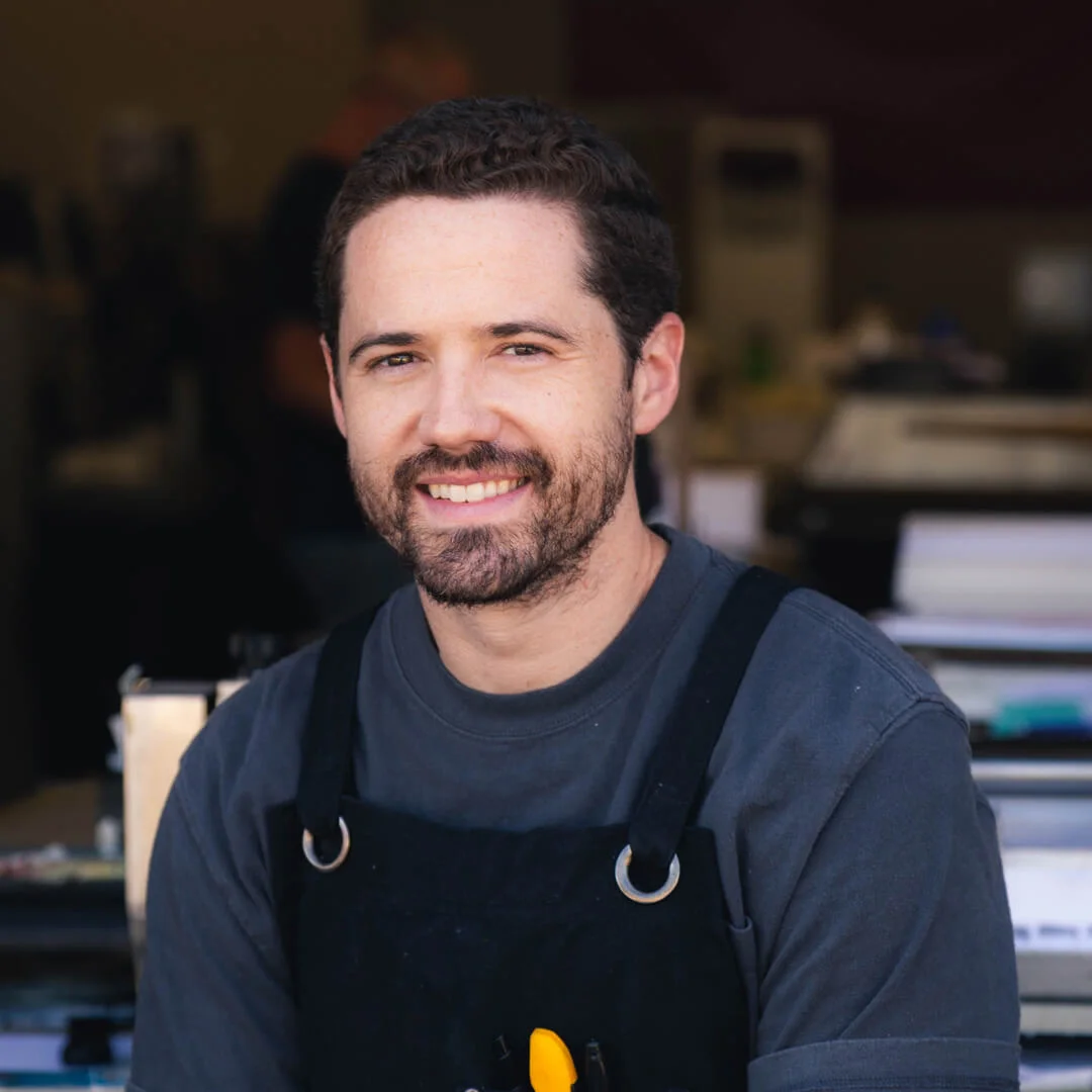 DANIEL Daniel has lived in California for over 10 years, but originally hails from Nashville, Tennessee. In his spare time, you can find him drumming for his band Able Body. He spent 5 years letterpressing in LA, and has been our trusty printer since moving to Orange County in 2018. Pantone: Process Black Font: Helvetica Paper: Savoy Brilliant White