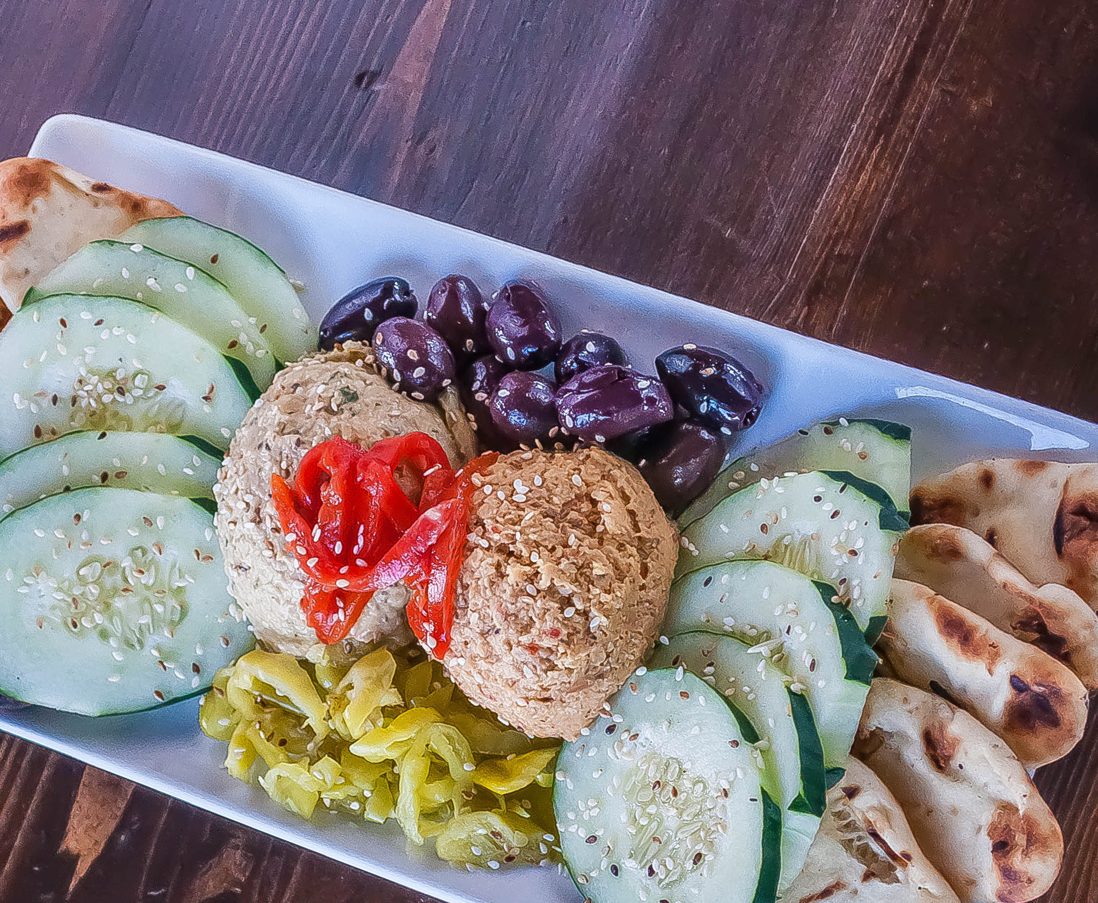 Fresh Meditteranean flavors come together in this delicious appetizer platter. House made hummus is paired with naan dippers, fresh peppers, olives and crisp cucumber slices.