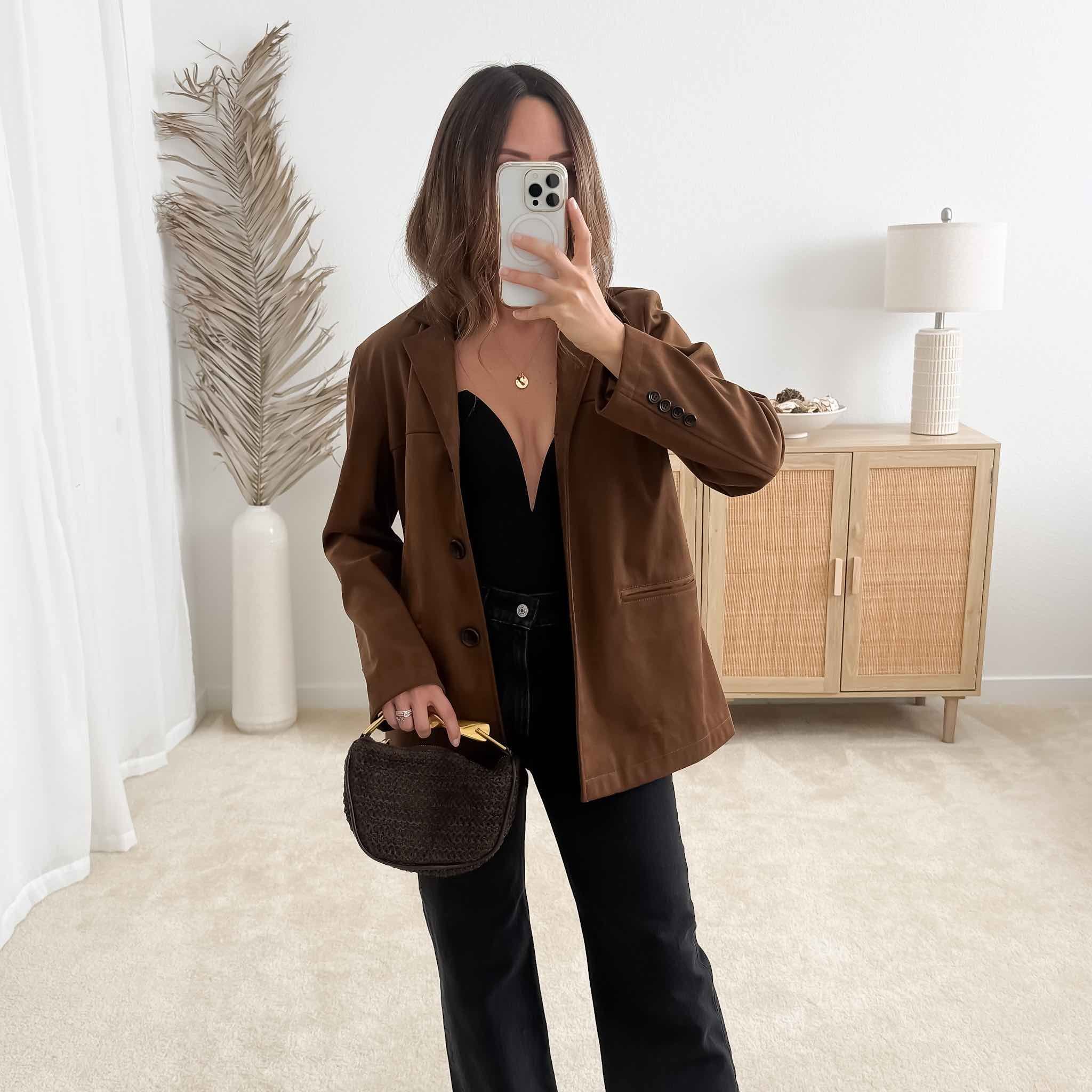 Chic neutral fall outfit for date night featuring fall capsule wardrobe essentials: brown suede blazer, black top, black jeans, brown clutch 