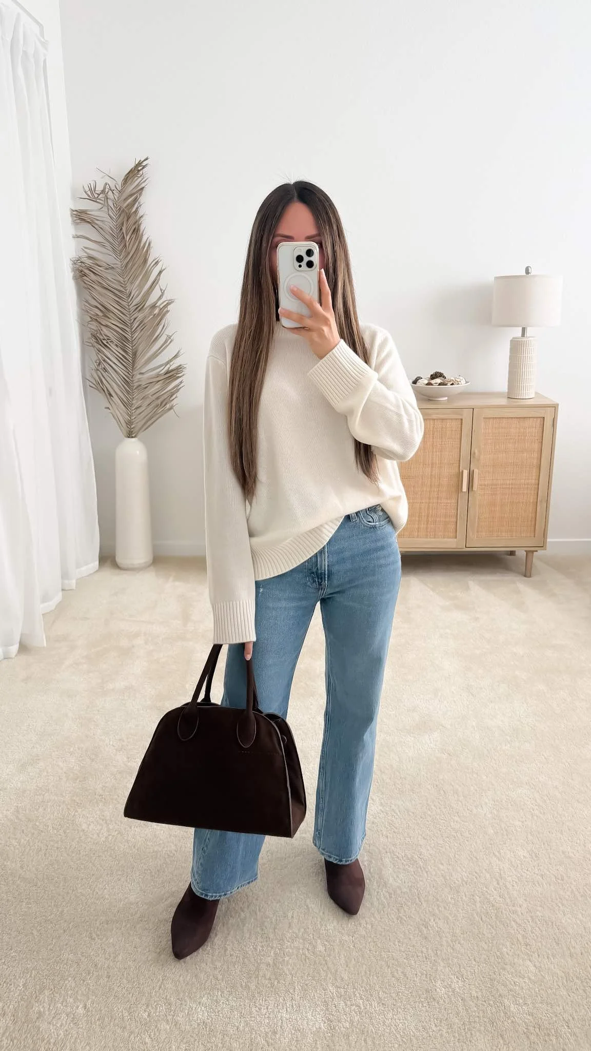 Sweater with jeans outfit featuring Quince Mongolian Cashmere Oversized Crewneck Sweater styled with straight-leg jeans, brown ankle boots, and a brown bag