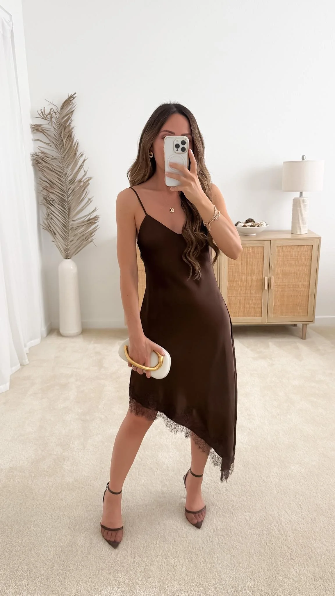 Brown satin asymmetrical lace fall wedding guest dress styled with strappy heels, gold jewelry, and a statement clutch