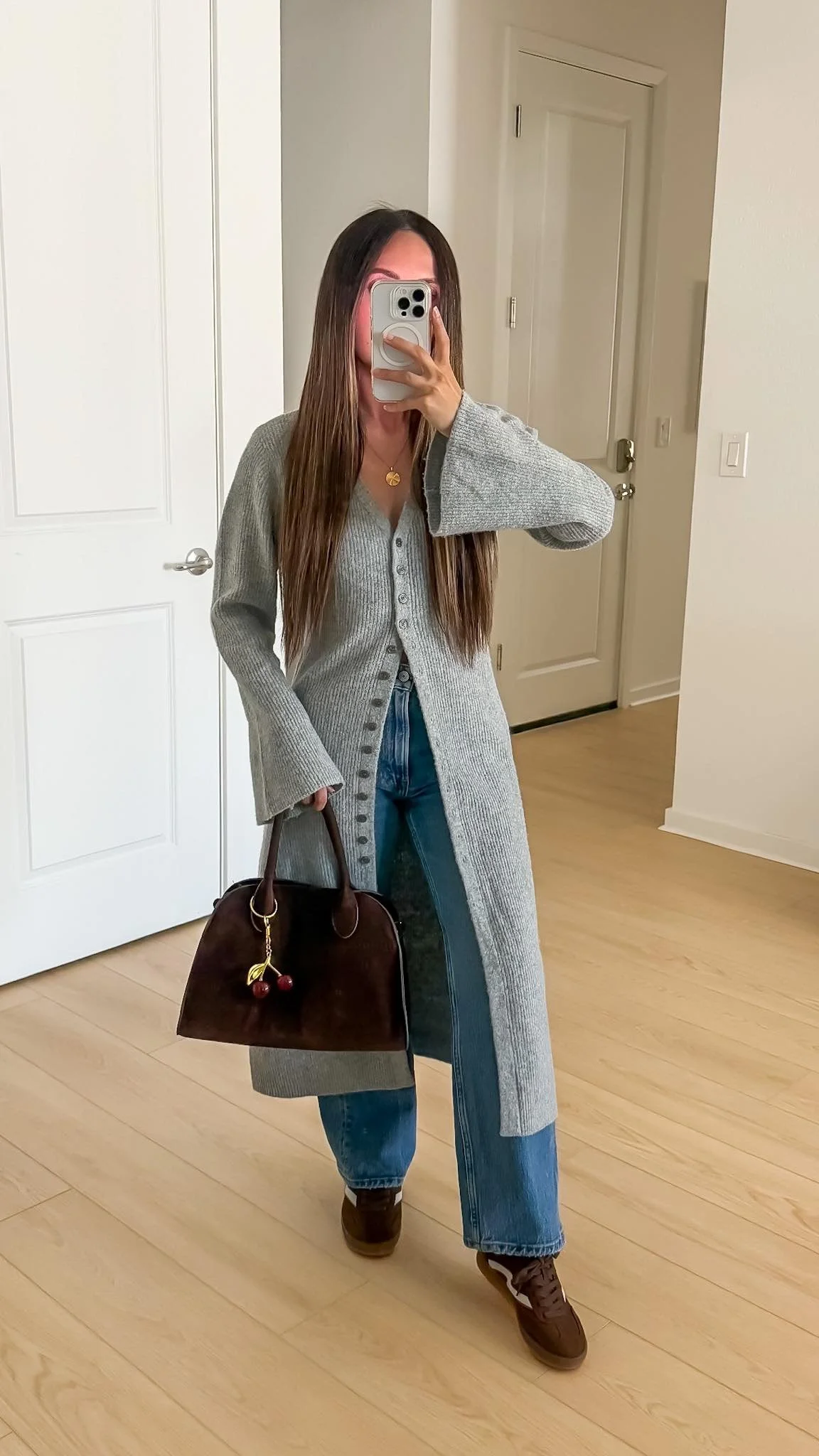Fall outfit with long gray cardigan, blue jeans, brown sneakers and brown suede bag