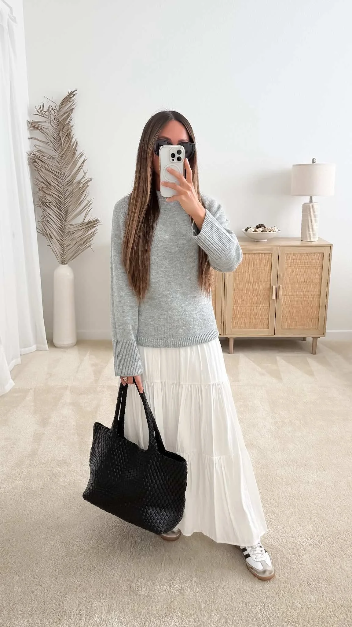 Fall outfit with gray sweater, white maxi skirt, sneakers, and black woven tote